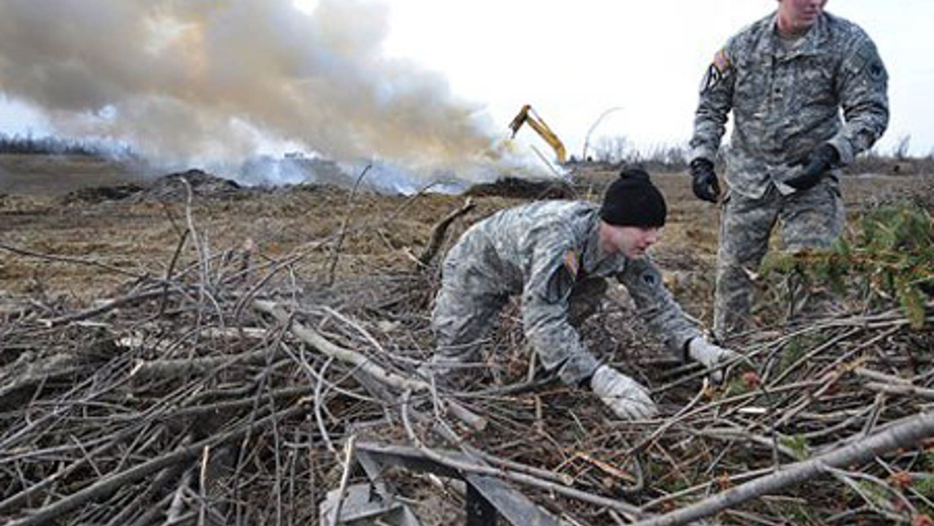 Feb. 2: Kentucky National guard members William Swartwood, left, and Jerry Bailey help unload branches from the back of a truck.