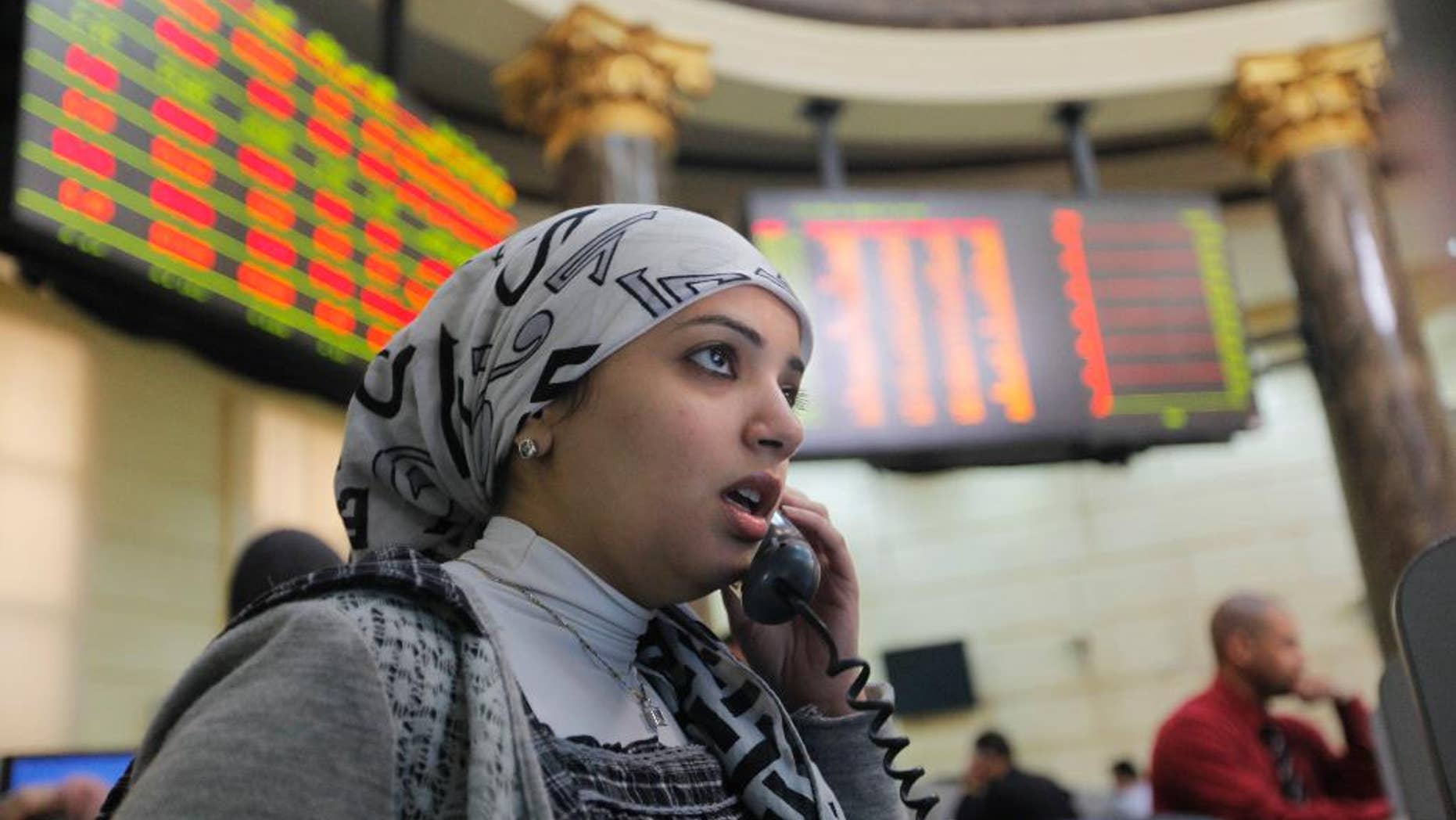 FILE - In this March 10, 2013 file photo, an Egyptian trader talks as she monitors her screen at the Egyptian Stock Exchange, in Cairo, Egypt. Dubai-based Emaar Properties, the property developer behind the record-breaking Burj Khalifa skyscraper in Dubai, said Wednesday, May 20, 2015, that it will float shares in its Egyptian subsidiary on the Egyptian Stock Exchange to raise cash for ongoing and future projects in the North African nation. (AP Photo/Amr Nabil, File)