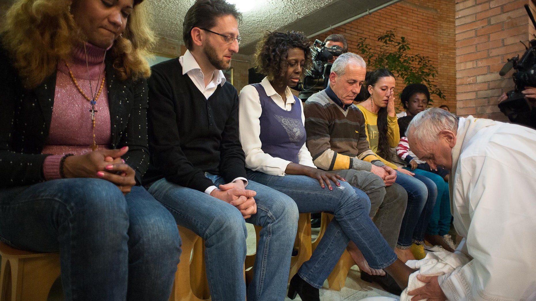 Pope Francis washes the foot of a woman at Rebibbia prison in Rome, Thursday, April 2, 2015.