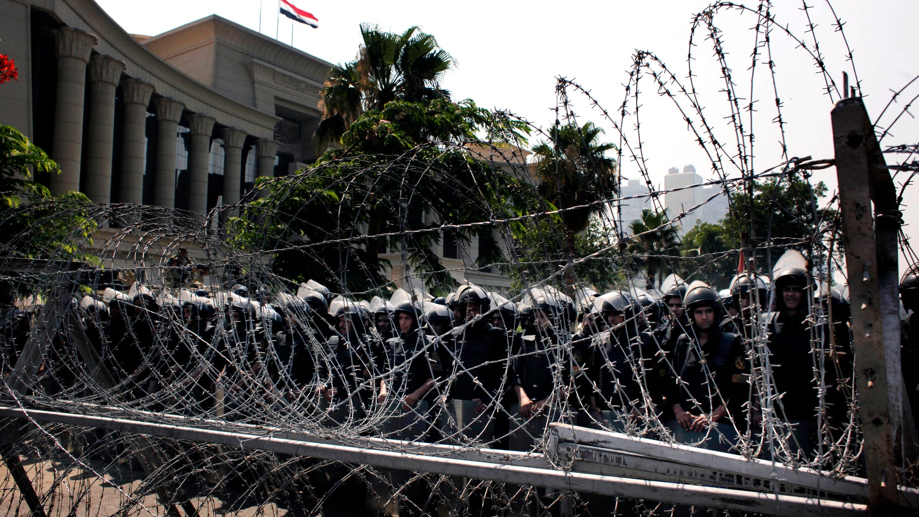 FILE - In this Thursday, June 14, 2012 file photo, Egyptian soldiers stand guard during a protest in front the Supreme Constitutional Court, Egypt's highest court, background, in Cairo, Egypt. Islamists and former members of the military have pushed back Sunday against the decision by Egypt’s Supreme Constitutional Court which states that barring members of the armed forces and police from voting goes against the country’s first constitution after the ouster of longtime authoritarian leader Hosni Mubarak. (AP Photo/Nasser Nasser, File)