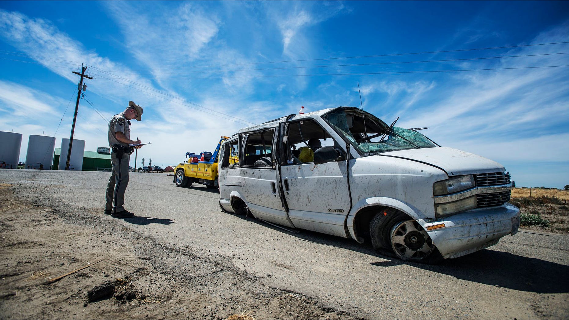 The California Highway Patrol investigate the scene of a single vehicle crash State Route 152 in Merced County, Calif., Saturday, June 20, 2015. Authorities said several farmworkers were killed and others hospitalized after a van overturned on the Central California highway. (Andrew Kuhn/Merced Sun-Star via AP) MANDATORY CREDIT