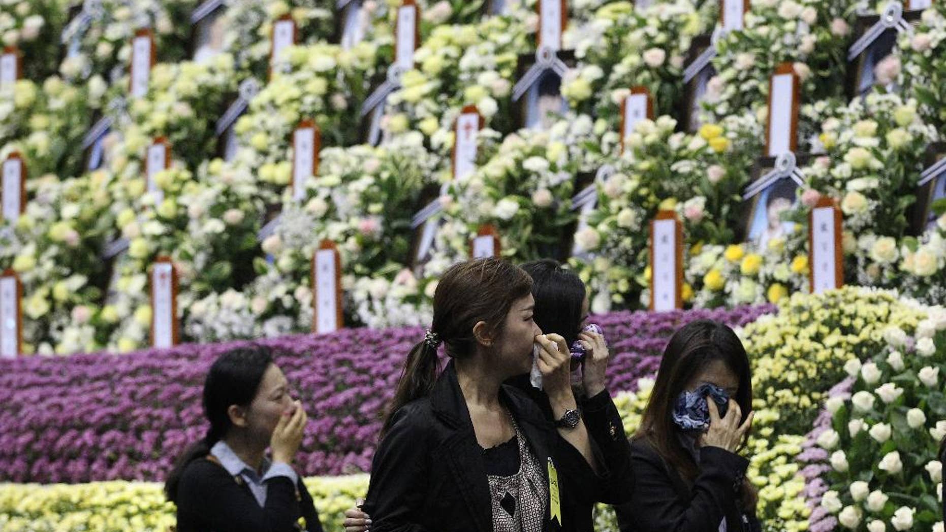 People weep as they pay tribute to the victims of the sunken ferry Sewol at a group memorial altar in Ansan, south of Seoul, South Korea, Tuesday, April 29, 2014. South Korean President Park Geun-hye apologized Tuesday for the government's inept initial response to a deadly ferry sinking as divers fought strong currents in their search for nearly 100 passengers still missing nearly two weeks after the accident.(AP Photo/Ahn Young-joon)
