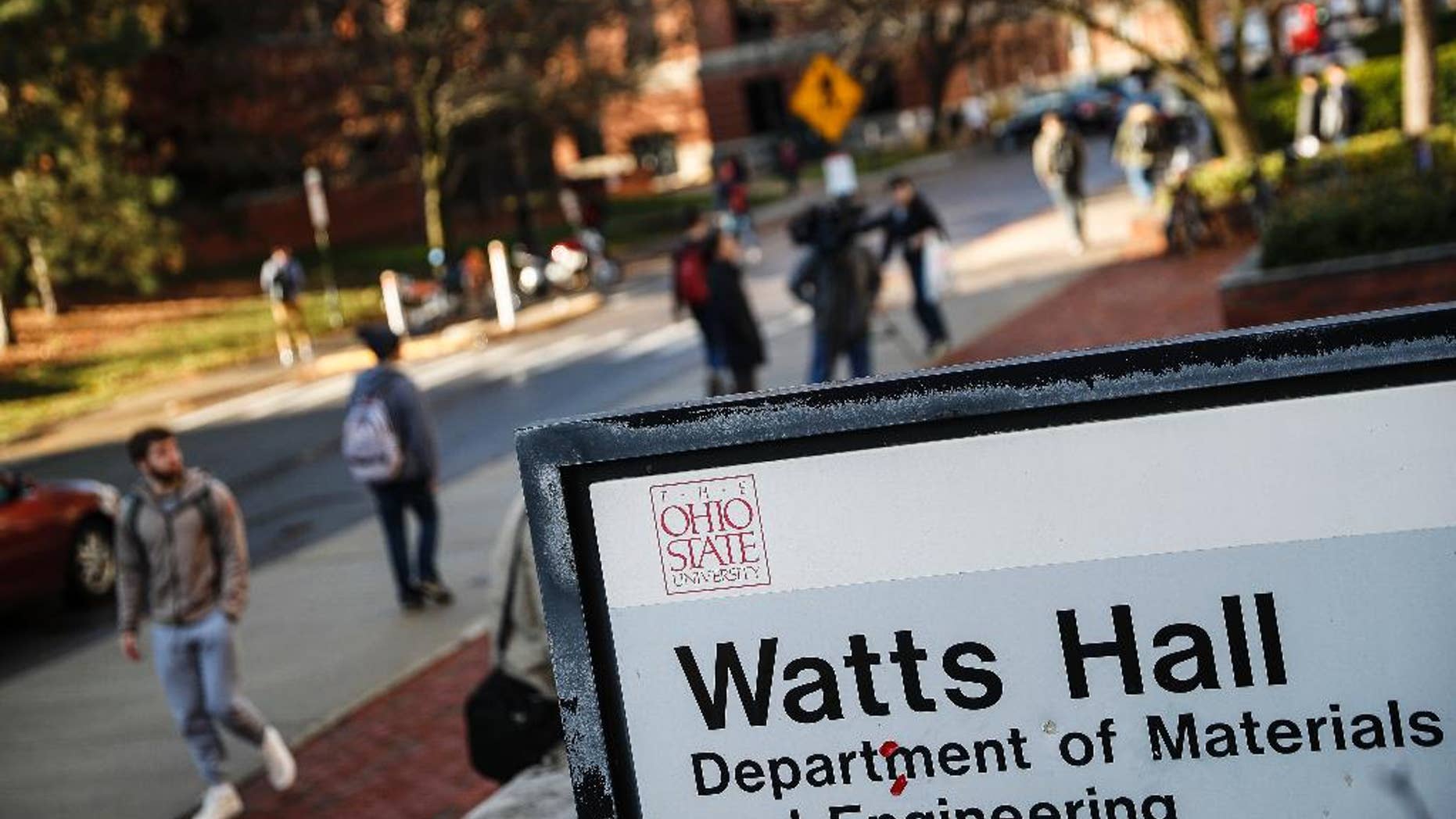 Students pass Watts Hall as they return to class following an attack at The Ohio State University campus the previous day, Tuesday, Nov. 29, 2016, in Columbus, Ohio. Investigators are looking into whether a car-and-knife attack at Ohio State University that injured several people was an act of terror. (AP Photo/John Minchillo)