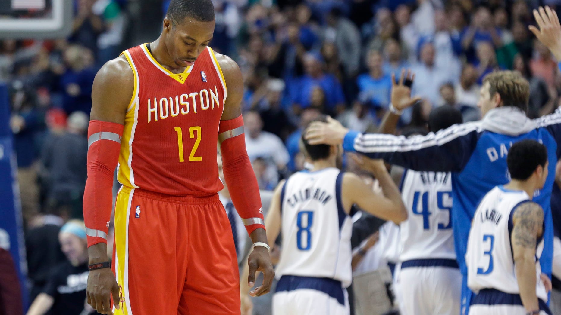 Houston Rockets forward Dwight Howard (12) hangs his head as he walks to the bench during a time out in the fourth quarter of an NBA basketball game against the Dallas Mavericks in Dallas, Wednesday, Nov. 20, 2013. The Mavericks won 123-120. (AP Photo/LM Otero)