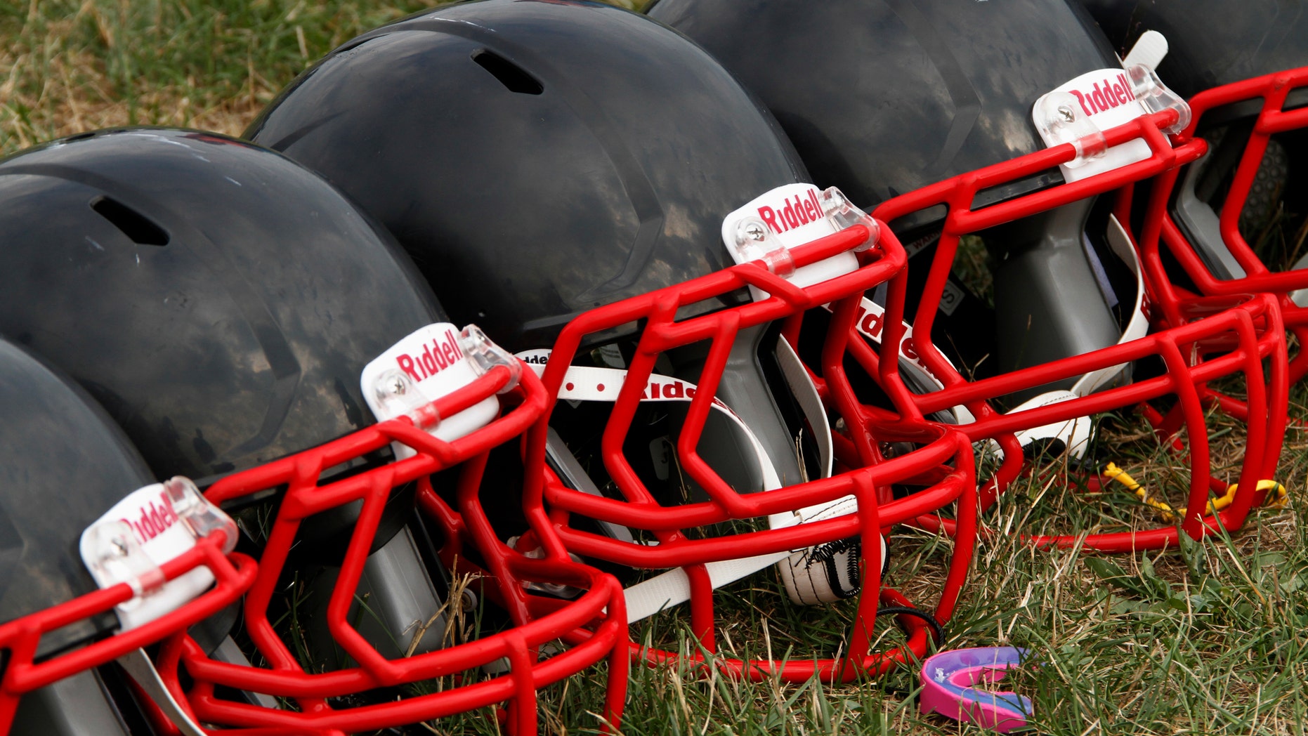 FILE - This Aug. 4, 2012 file photo shows new football helmets that were given to a group of youth football players from the Akron Parents Pee Wee Football League, in Akron, Ohio. It's not just football. A new report says too little is known about concussion risks for young athletes, and it's not clear whether better headgear is an answer. The panel stresses wearing proper safety equipment. But it finds little evidence that current helmet designs, face masks and other gear really prevent concussions, as ads often claim. (AP Photo/Gene J. Puskar, File)