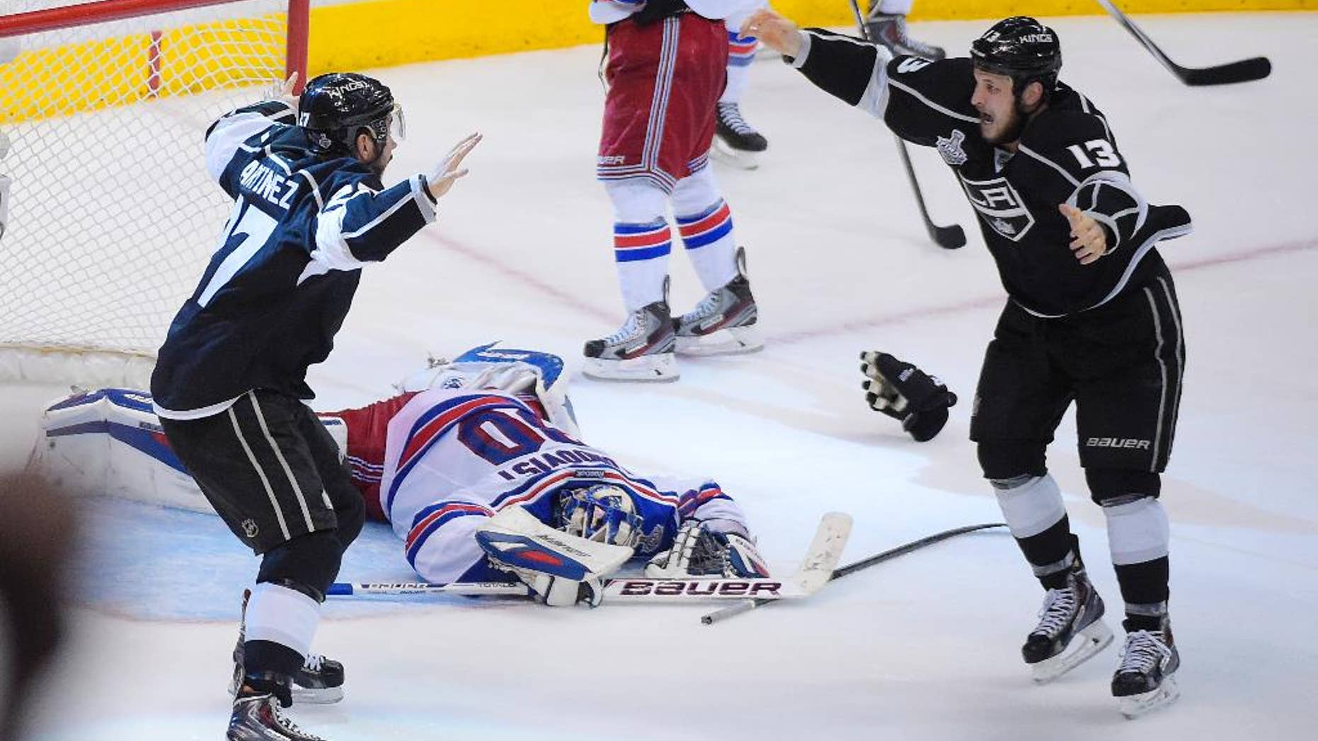 Los Angeles Kings defenseman Alec Martinez, left, celebrates after scoring the winning goal with Kyle Clifford, right, past New York Rangers goalie Henrik Lundqvist, of Sweden, during the second overtime period in Game 5 of an NHL hockey Stanley Cup finals, Friday, June 13, 2014, in Los Angeles. (AP Photo/Mark J. Terrill)