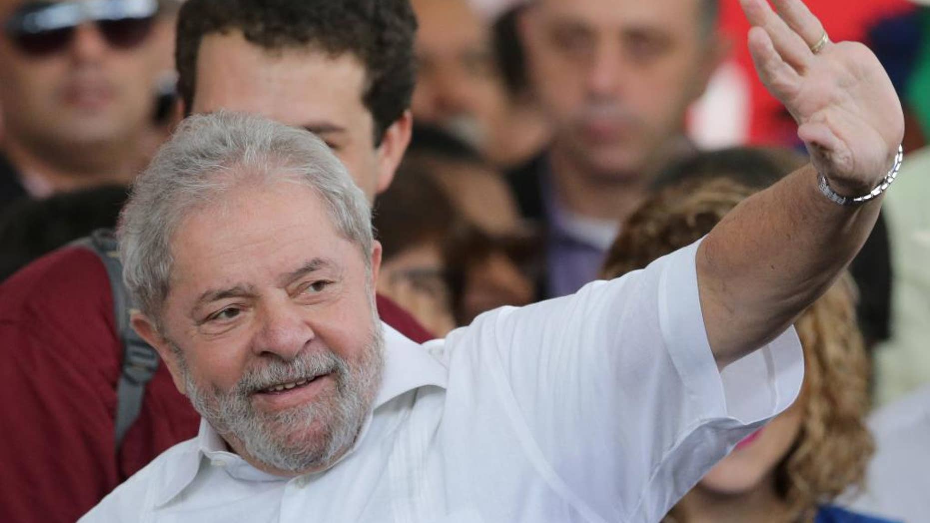 Brazil's former President Luiz Inacio Lula da Silva gestures to the crowd while arriving to a rally of Social Movements for Democracy, in a camp set up by supporters of President Dilma Rousseff in Brasilia, Brazil, Saturday, April 16, 2016. The lower chamber of Brazil's Congress on Friday began a debate on whether to impeach Rousseff, a question that underscores deep polarization in Latin America's largest country and most powerful economy. The crucial vote is slated for Sunday. (AP Photo/Eraldo Peres)
