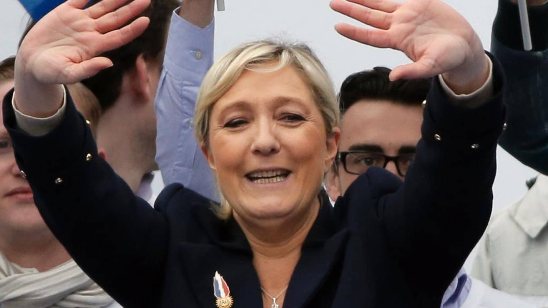 France’s far-right National Front president Marine Le Pen waves to supporters after her speech at Opera Plaza during the annual May Day march, in Paris, France, Friday, May 1, 2015. France’s far-right National Front is holding its annual May Day march, but for the first time the party’s founder Jean-Marie Le Penis not taking a seat at the tribune. (AP Photo/Francois Mori)