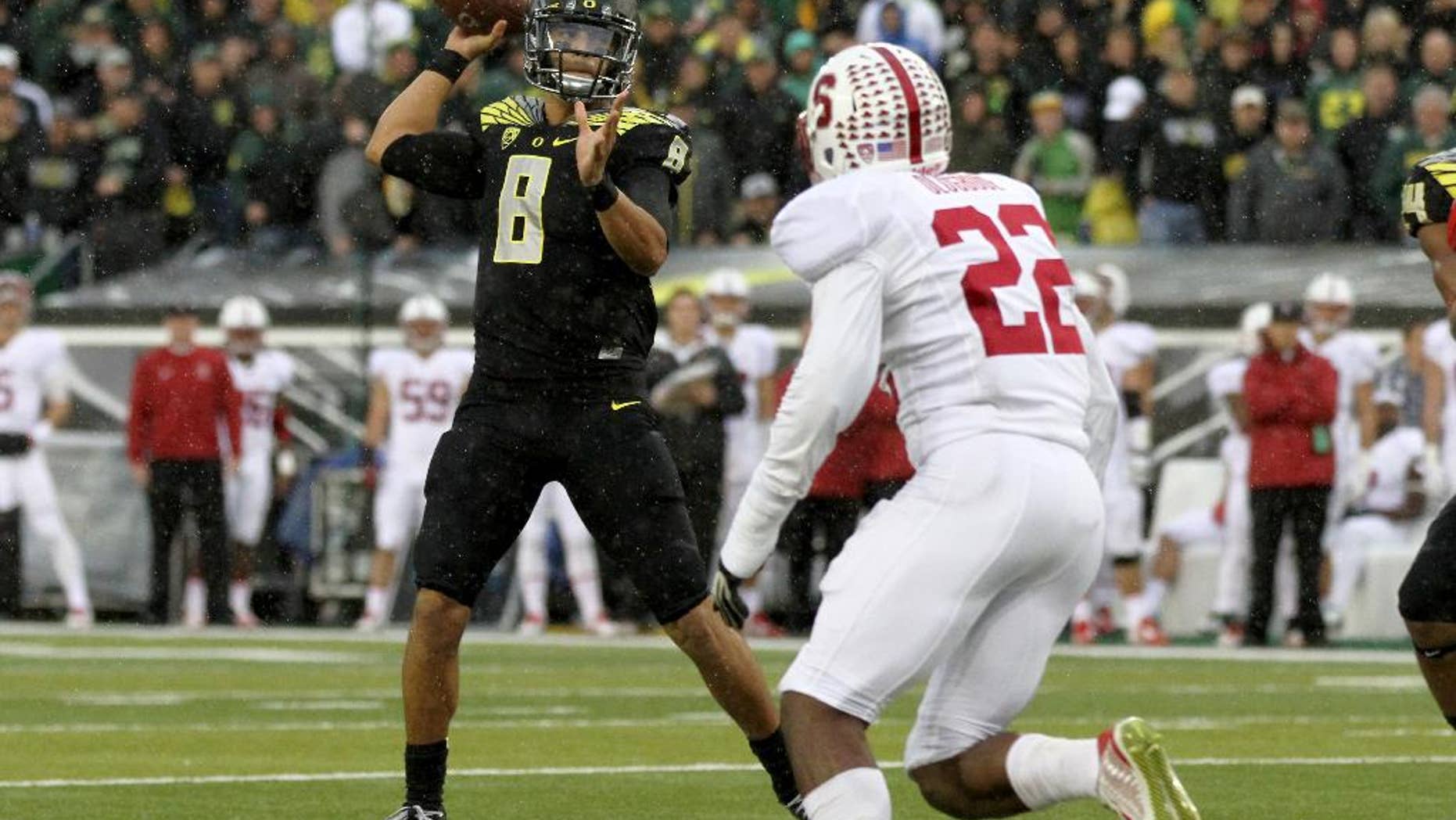 Oregon quarterback Marcus Mariota (8) looks to throw towards the end zone during the first quarter against Stanford in an NCAA college football game in Eugene, Ore., Saturday, Nov. 1, 2014. (AP Photo/Ryan Kang)