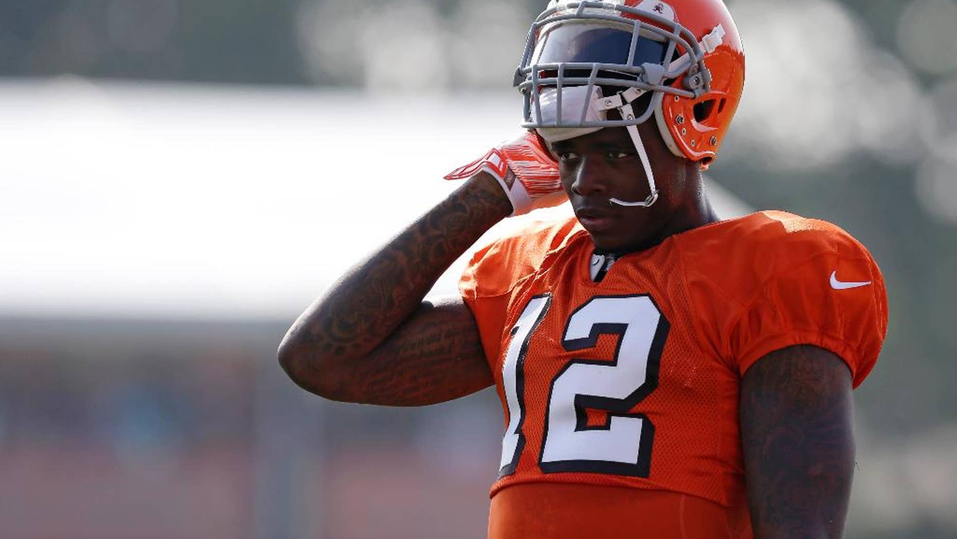 FILE - In this Aug. 4, 2014, file photo, Cleveland Browns wide receiver Josh Gordon rests during practice at the NFL football team's training campin Berea, Ohio. Gordon says the only place he can find peace is on the football field. His time there could be running short. The Browns' star receiver is awaiting word from the NFL on whether he'll be suspended for all or part of the season for violating the league's substance-abuse program. (AP Photo/Tony Dejak, File)