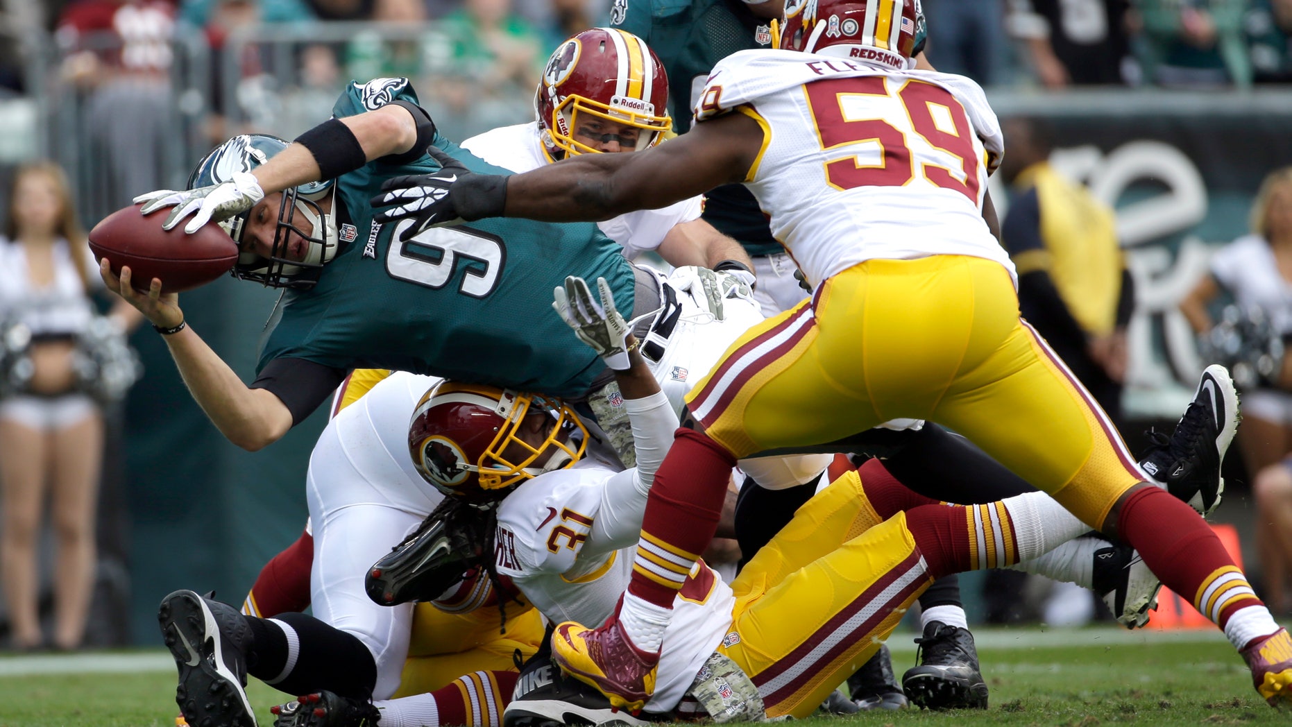 Philadelphia Eagles quarterback Nick Foles (9) dives into the end zone for a touchdown as Washington Redskins inside linebacker London Fletcher (59) reaches to stop him during the first half of an NFL football game in Philadelphia, Sunday, Nov. 17, 2013. (AP Photo/Matt Slocum)