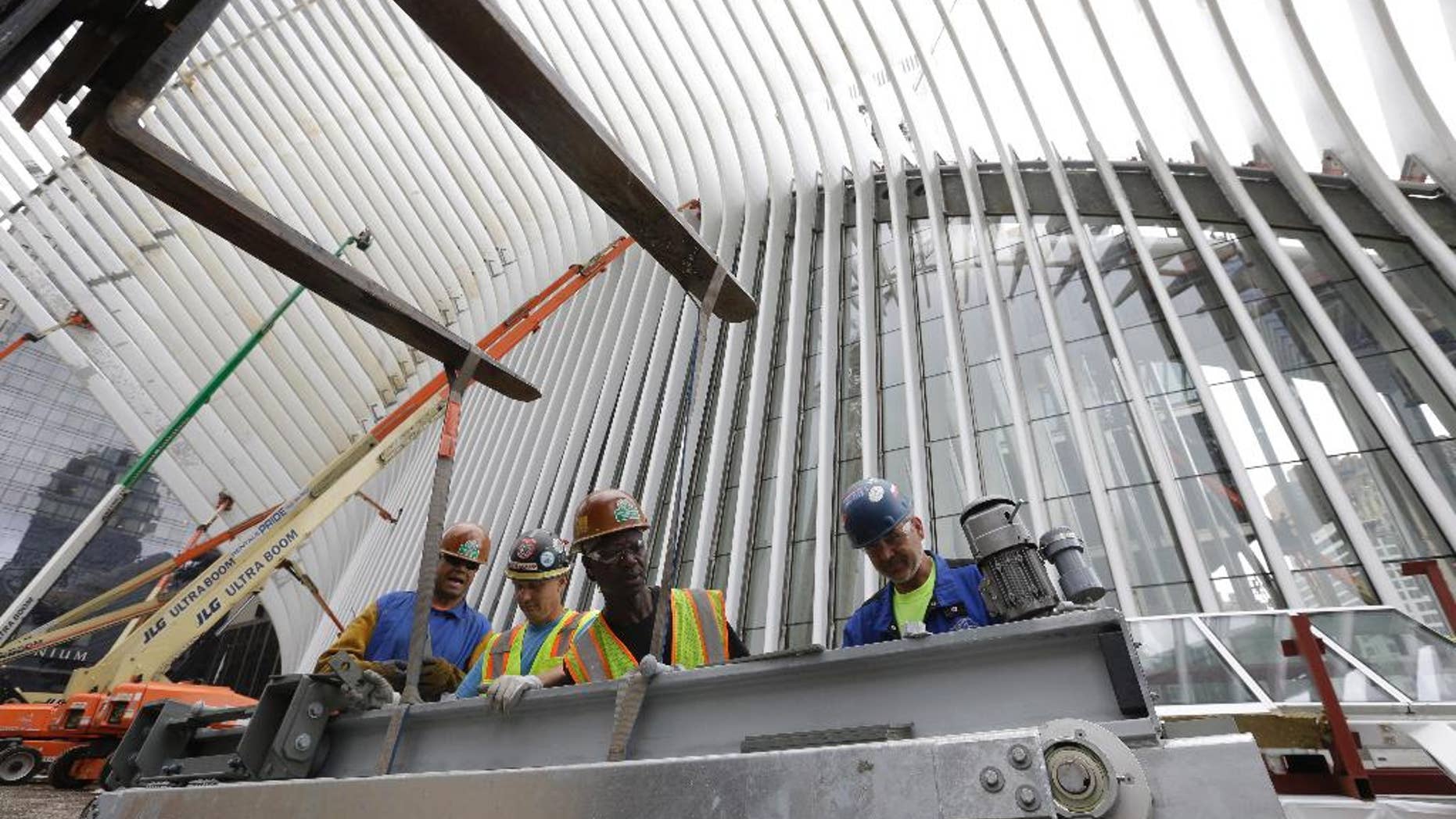 FILE - In this June 18, 2015, file photo, construction workers secure a steel apparatus to a crane that will be used on the roof of the Oculus structure at the World Trade Center transportation hub, in New York. The Commerce Department reports on U.S. construction spending in May on Wednesday, July 1, 2015. (AP Photo/Mary Altaffer, File)