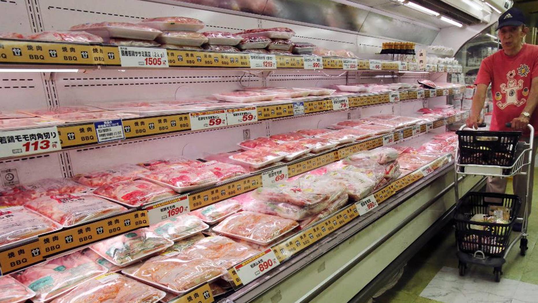 In this June 26, 2015 photo, a man shops at a supermarket in Tokyo. Japan's inflation rate and household spending slowed in July, according to data released Friday, Aug. 28, 2015 that will likely raise pressure on the central bank to up its barrage of monetary stimulus. (AP Photo/Koji Sasahara)