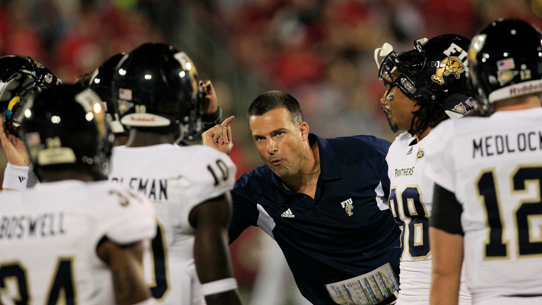 FILE - This Sept. 9, 2011 file photo shows Florida International coach Mario Cristobal talking with his players during the second half of their NCAA college football game against Louisville in Louisville, Ky. A person familiar with the situation says Cristobal is returning to Miami as the Hurricanes' associate head coach. The person spoke to The Associated Press Thursday, Jan. 10, 2013, on condition of anonymity because the hiring had not been announced by the Hurricanes. (AP Photo/Ed Reinke, File)