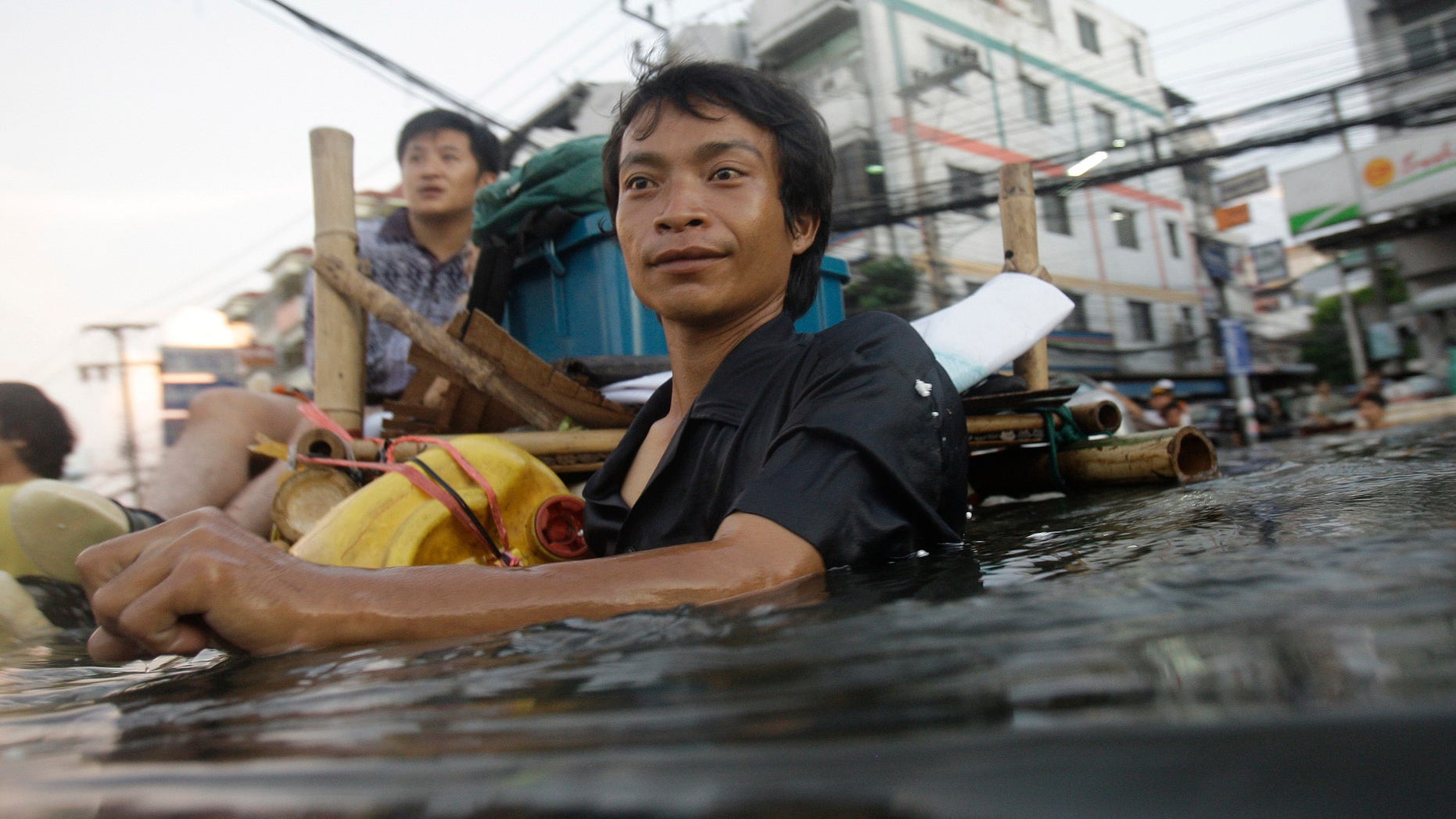Oct. 27, 2011: A Thai man wades along chest-deep floodwaters in the outskirts of Bangkok, Thailand.