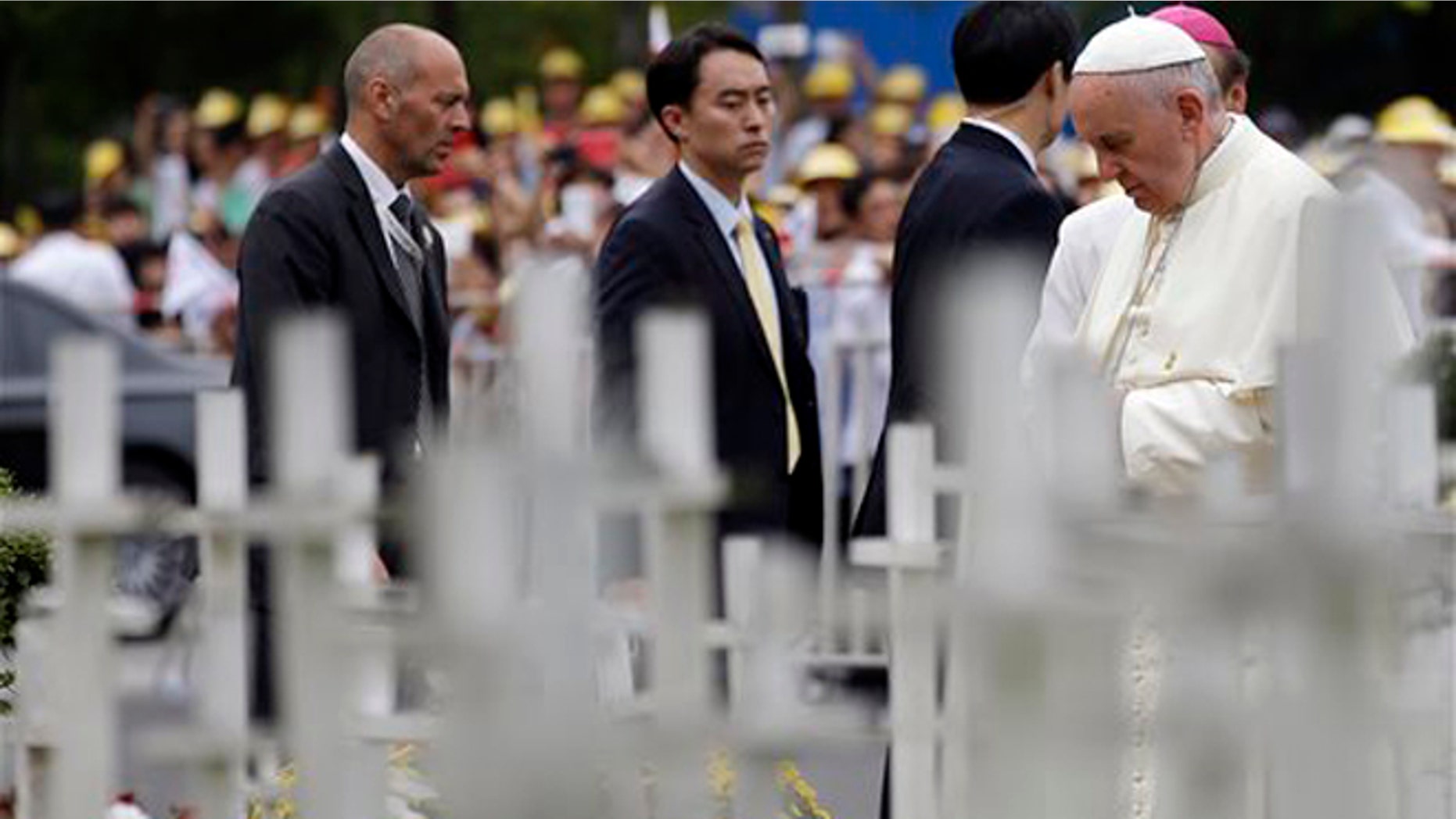 Pope Francis prays in front of white wooden crosses of the unborn children garden during his visit to the "House of Hope" center for disabled in Kkottongnae, South Korea, Saturday, Aug. 16, 2014. Francis bowed his head in prayer before the monument and spoke with an anti-abortion activist with no arms and no legs. (AP Photo/Gregorio Borgia)