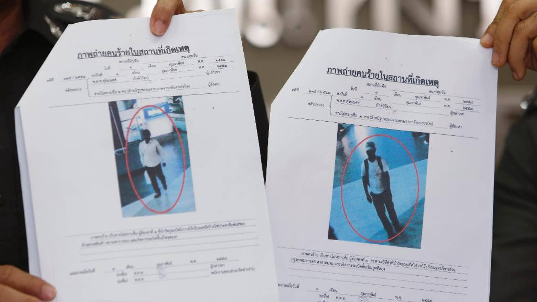 Photos of two suspects believed linked to a pair of small bomb blasts outside a luxury shopping mall in Bangkok over the weekend, are shown by police officers at the police headquarters in Bangkok, Thailand Wednesday, Feb. 4, 2015. Authorities in Thailand have issued arrest warrants for the two suspects. The blurry images of the suspects, described as "Asian-looking" by a police spokesman, were captured on closed-circuit camera footage close to where the homemade pipe bombs detonated and wounded one person. (AP Photo/Sakchai Lalit)