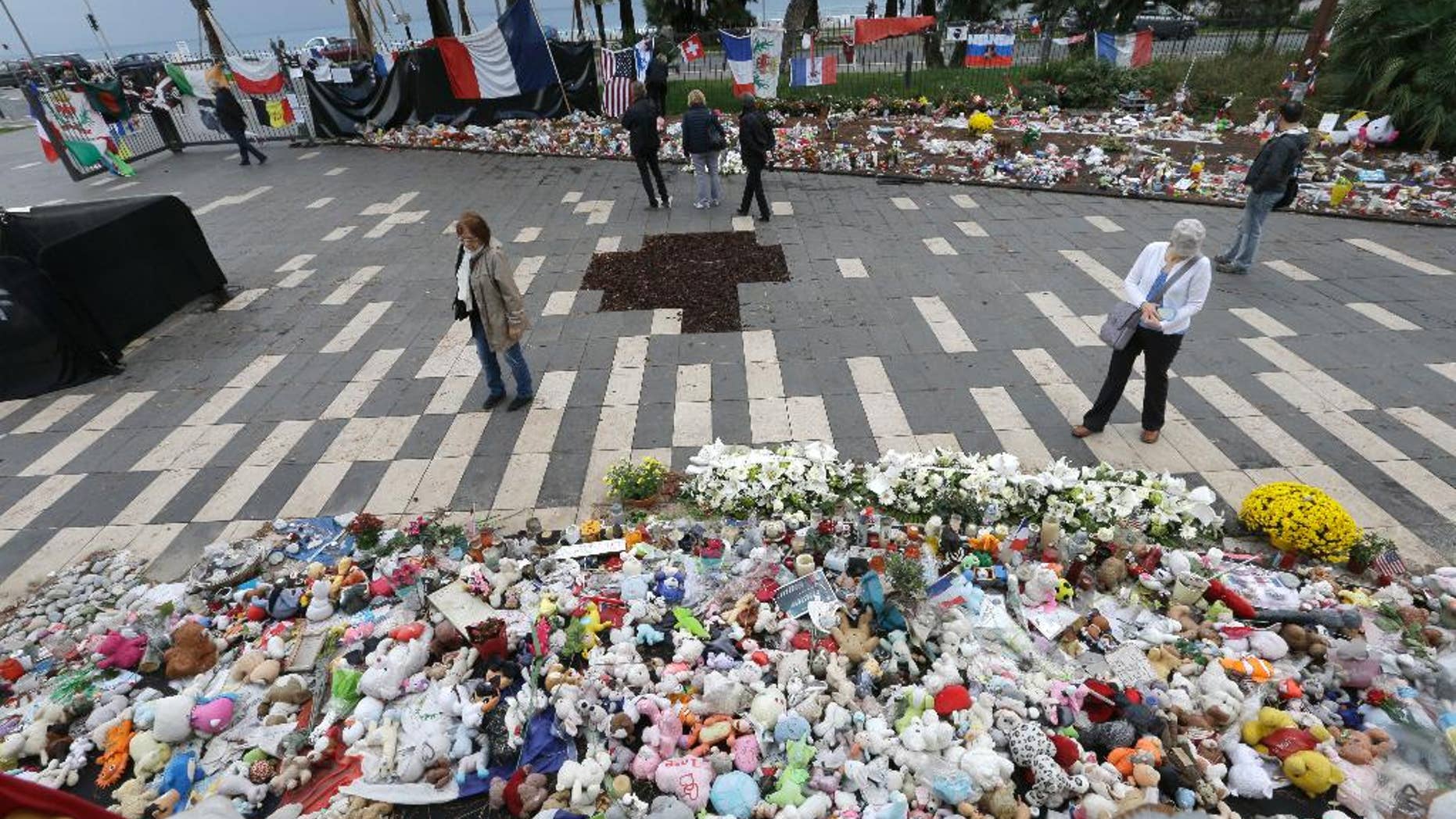 FILE - In this file photo dated Thursday, Oct. 14, 2016, showing floral tributes at a makeshift memorial in a park on the Nice's famed Promenade des Anglais, on the eve of a national commemoration to the victims of the Nice attack in southern France. A French prosecutor Jean-Michel Pretre said Wednesday April 5, 2017, two judges will investigate allegations that French authorities and the southern city of Nice failed to implement proper security measures which may have stopped a man who drove a truck into crowds leaving scores of dead. (AP Photo/Claude Paris, FILE)
