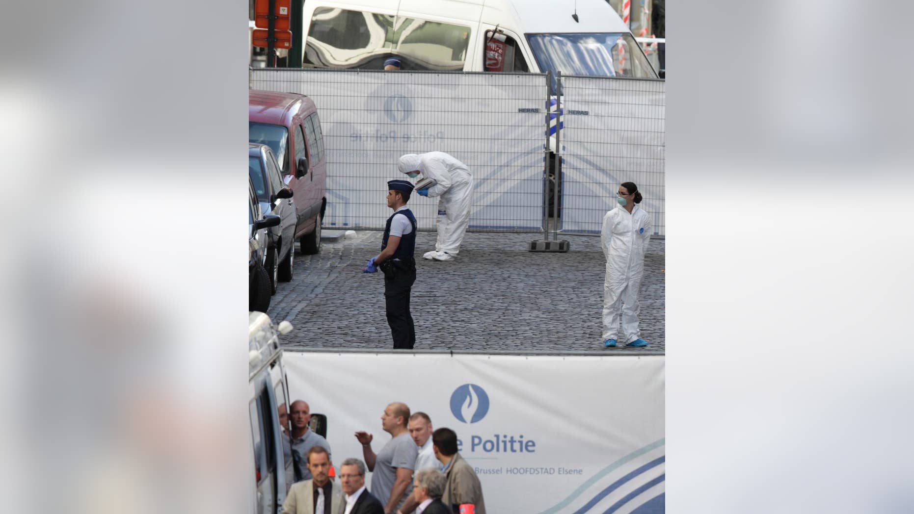 Forensic experts examine the site of a shooting at the Jewish museum in Brussels, Saturday, May 24, 2014. Belgian officials say that at least three people have been killed in gunfire at the Jewish Museum in Brussels. Belgian Foreign Minister Didier Reynders, in a post on Twitter, said he was "shocked by the murders committed at the Jewish Museum" on Saturday afternoon. He said he had seen the bodies of the victims. At least three persons were killed in the incident, and a Brussels fire department spokesman said one person was wounded. (AP Photo/Yves Logghe)