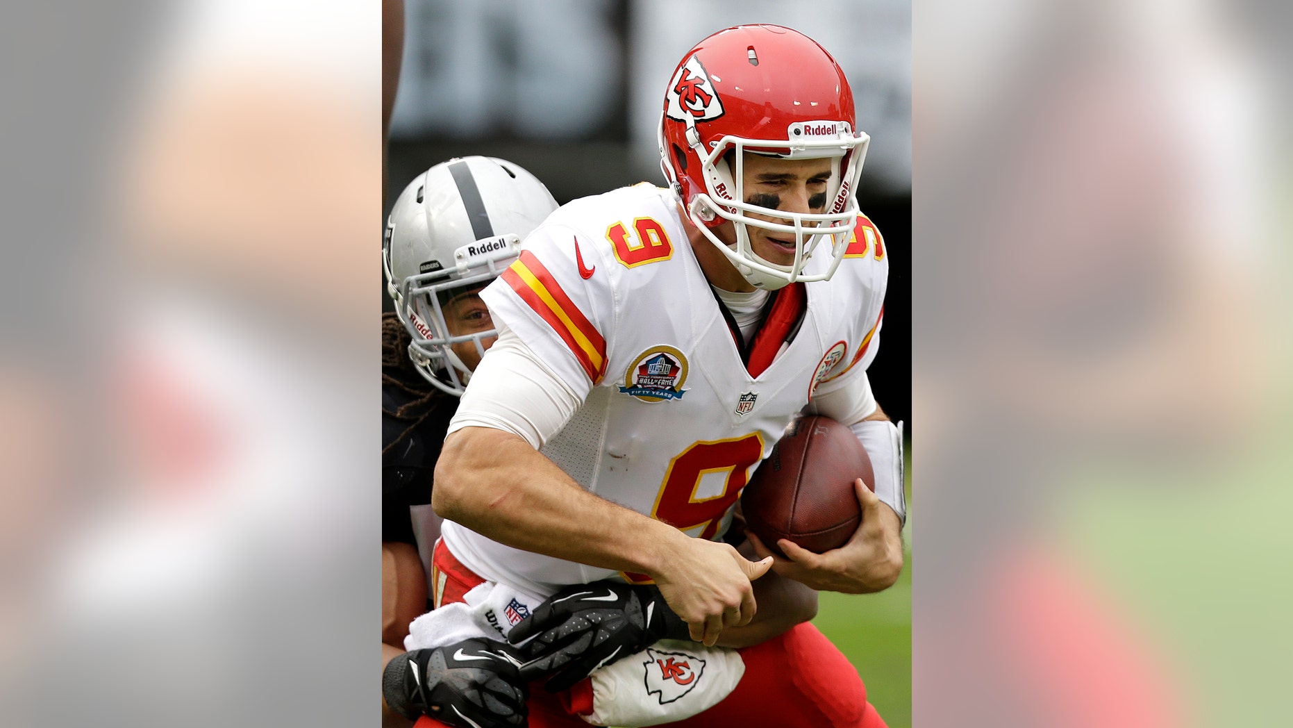 FILE - In this Dec. 16, 2012, file photo, Kansas City Chiefs quarterback Brady Quinn (9) is sacked by Oakland Raiders linebacker Philip Wheeler during the second quarter of an NFL football game in Oakland, Calif. Quinn is the new backup quarterback for the Seattle Seahawks after agreeing to terms with the club. The deal was announced by the team on Tuesday, April 9, 2013. (AP Photo/Marcio Jose Sanchez, File)