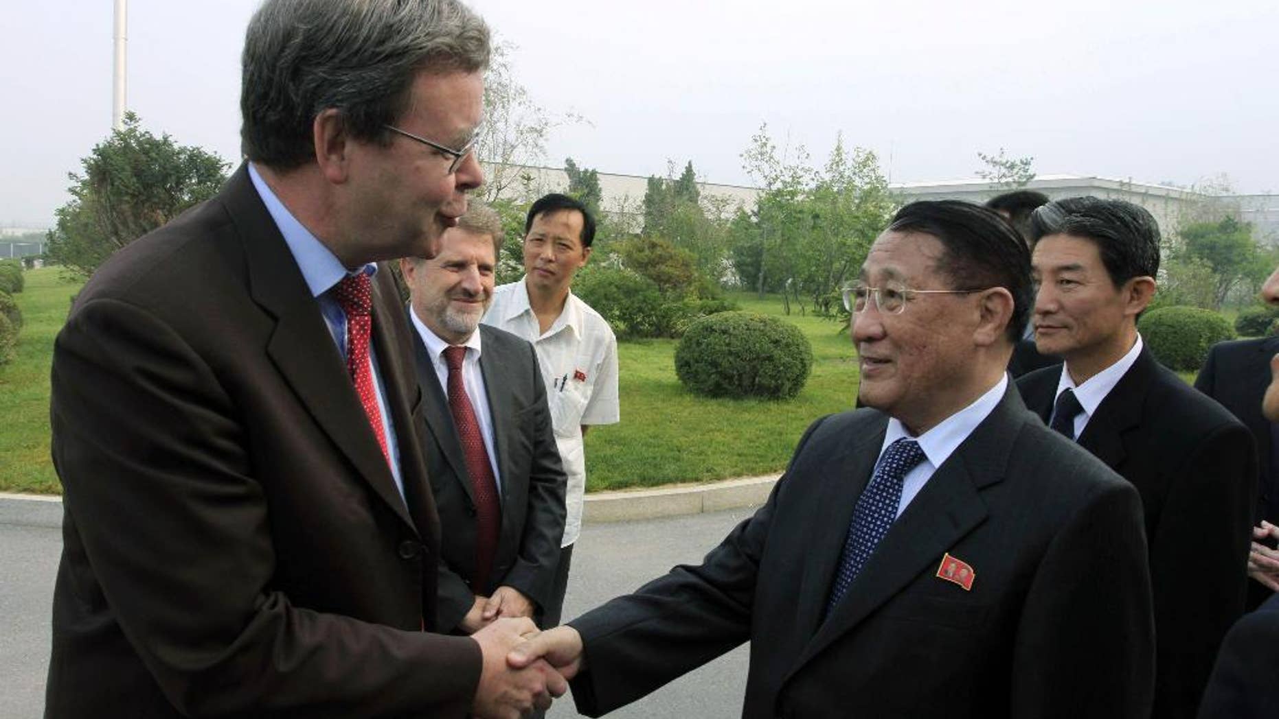 FILE - In this Sept. 6, 2014 file photo, North Korea's Kang Sok Ju, right, a member of the Political Bureau of the Central Committee of the Workers' Party of Korea (WPK) and secretary of the WPK, shakes hands with German Ambassador to North Korea Thomas Schaefer as he leaves Pyongyang Airport in Pyongyang, North Korea to visit Germany, Belgium, Switzerland, Italy and Mongolia. Kang, a top North Korean diplomat who negotiated a short-lived 1994 deal with the United States to freeze its nuclear programs in exchange for international aid, has died of cancer, the country's state media said Saturday, May 21, 2016. (AP Photo/Kim Kwang Hyon, File)