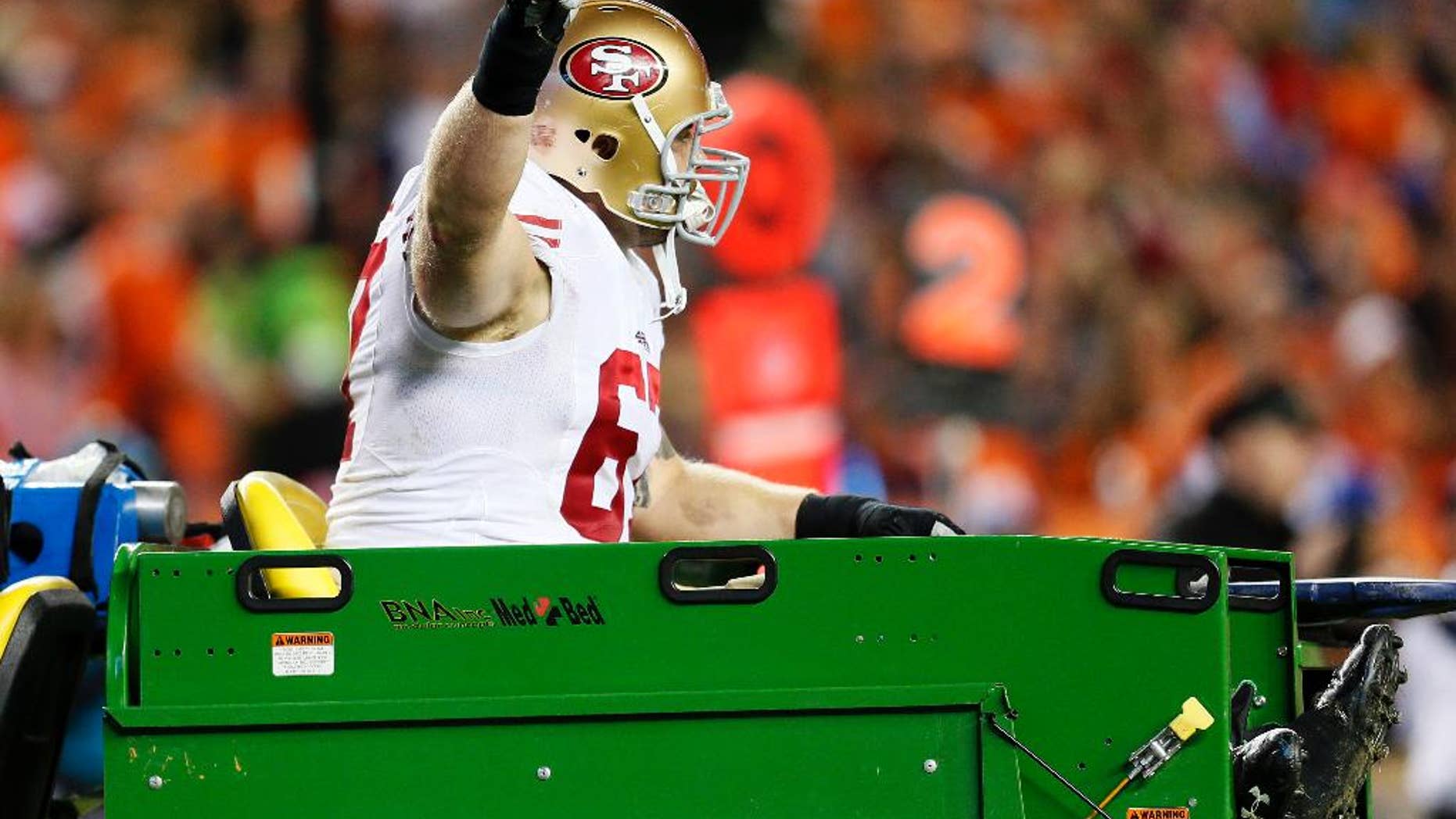 San Francisco 49ers center Daniel Kilgore gives the thumbs up as he is carted off the field against the Denver Broncos during the second half of an NFL football game, Sunday, Oct. 19, 2014, in Denver. (AP Photo/Joe Mahoney)