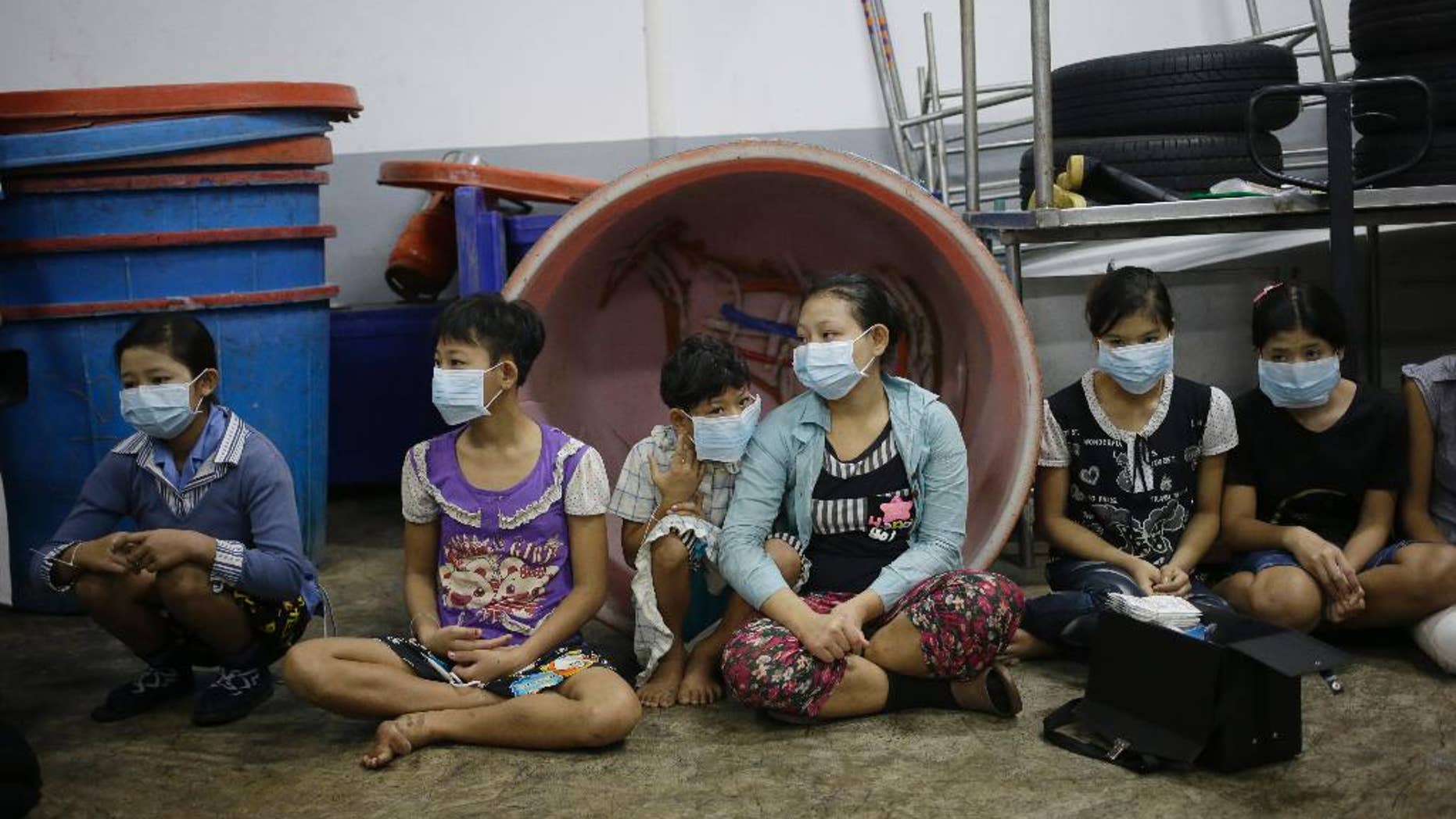 FILE - In this file photo taken Nov. 9, 2015, children and teenagers sit together to be registered by officials during a raid on a shrimp shed in Samut Sakhon, Thailand. On Tuesday a global slavery index puts India at the top of the list with the world's highest number of bonded and child laborers, far more than in second-place China. (AP Photo/Dita Alangkara, File)