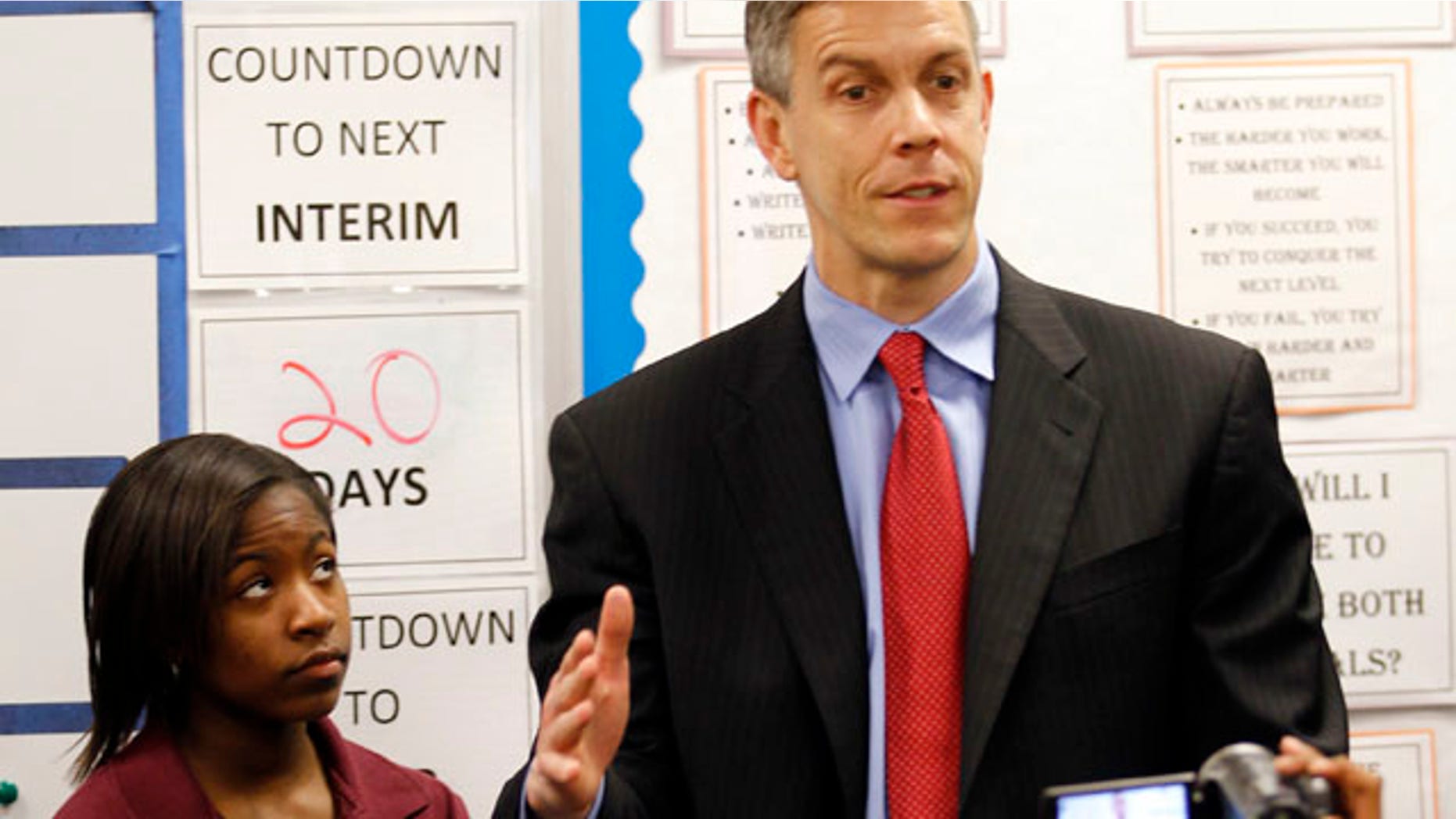 FILE - In this April 15, 2011 file photo, student Faith Brown, left, listens as U.S. Department of Education Secretary Arne Duncan speaks to students during tour the Charles A. Tindley Accelerated School in Indianapolis. Duncan says he will announce a new waiver system Monday, Aug. 8, 2011, to give schools a break from student testing mandates in the federal No Child Left Behind law. (AP Photo/Michael Conroy, File)