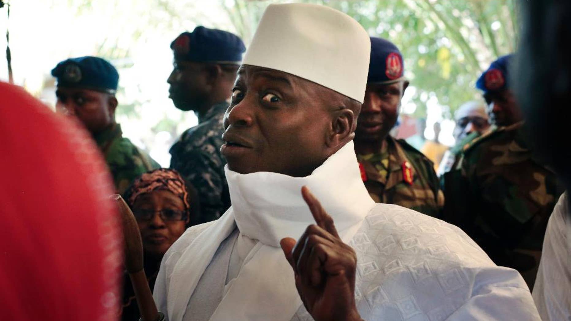 FILE- In this Thursday, Dec. 1, 2016 file photo, Gambia's president Yahya Jammeh shows his inked finger before voting in Banjul, Gambia. President Yahya Jammeh, who at first surprised Gambians by conceding defeat after 22 years in power, a week later announced that he had changed his mind. He alleges voting irregularities that make the Dec. 1 ballot invalid. (AP Photo/Jerome Delay, File)