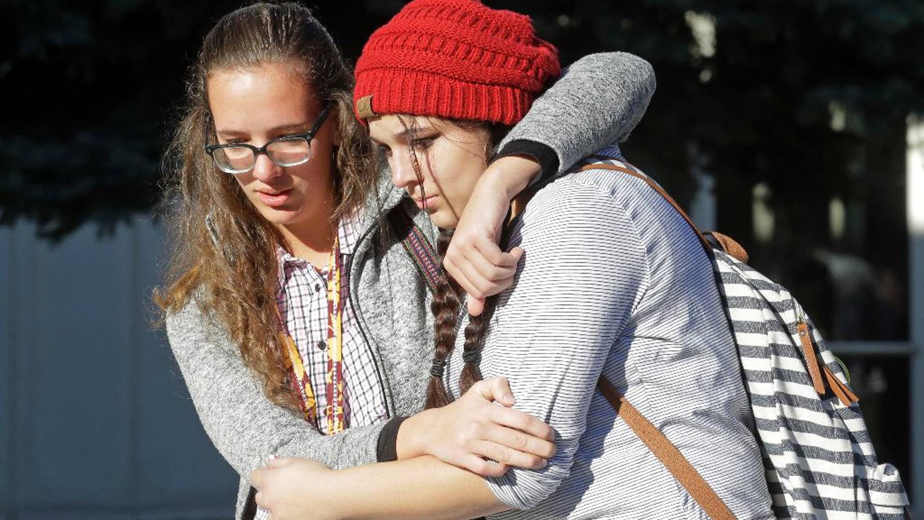 Students Albany Cox, right, and Holly Hilton leave Mountain View High School where several students were stabbed Tuesday.