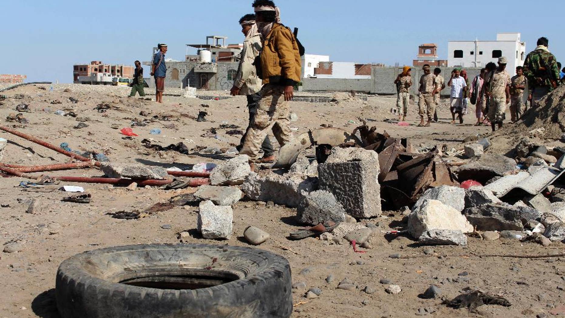 FILE - In this Sunday, Dec. 18, 2016 file photo, soldiers gather the site of a suicide bomb at a base in the southern city of Aden, Yemen. On a rocky hill overlooking the Arabian Sea in the southern city of Aden sits the heavily fortified palace of Yemen’s internationally recognized president. It’s one of the few safe places in the country for him and his government, protected by troops at the gates and artilleries and truck-mounted machine guns in the surrounding mountains while naval forces guard him from the sea. (AP Photo/Wael Qubady, File)
