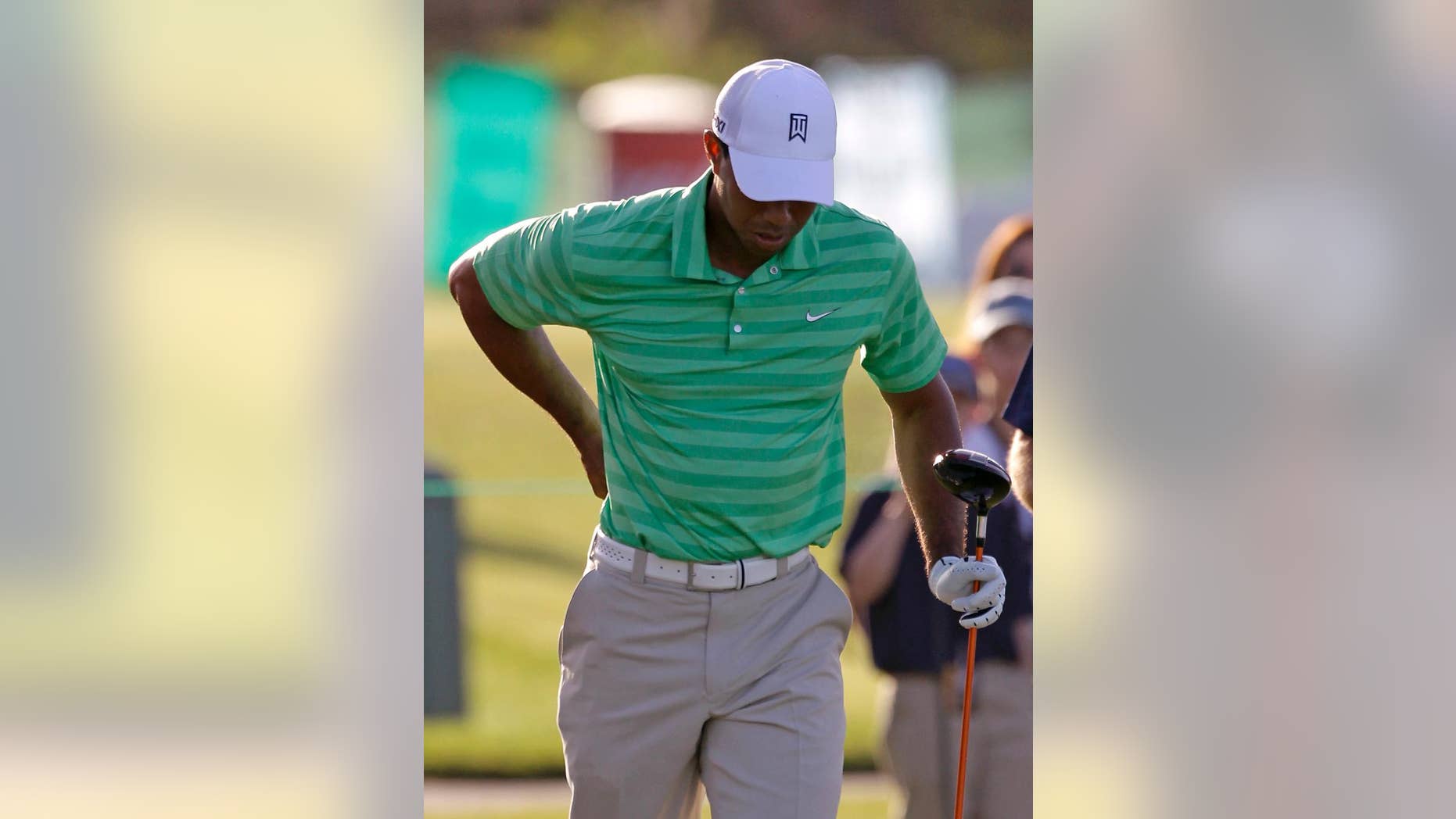 FILE - In this March 21, 2012 file photo, Tiger Woods rubs his back after his tee shot on the sixth hole during the Pro-Am round at the Arnold Palmer Invitational golf tournament at Bay Hill in Orlando, Fla. Woods says his recovery from back surgery is going slowly and he's not sure when he'll be able to return to golf. In a wide-ranging blog on his website Monday, May 5, 2014, Woods says he remains sore from the incision during the March 31 operation for a pinched nerve. (AP Photo/John Raoux, File)