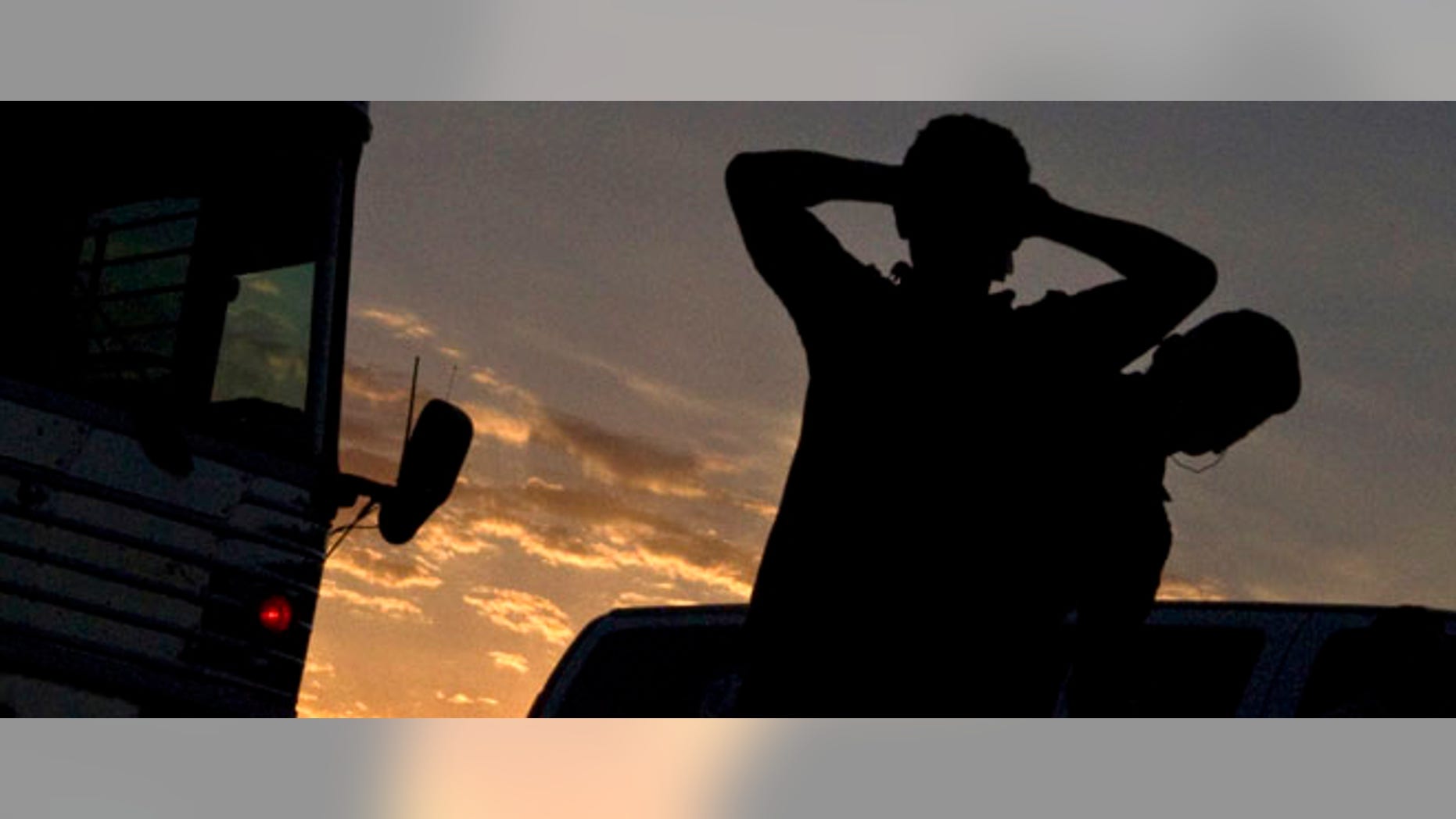 An immigrant is searched on the tarmac prior to boarding an MD-80 aircraft for a repatriation, Tuesday, June 26, 2012 at Phoenix-Mesa Gateway Airport in Mesa, Ariz. (AP Photo/Matt York)