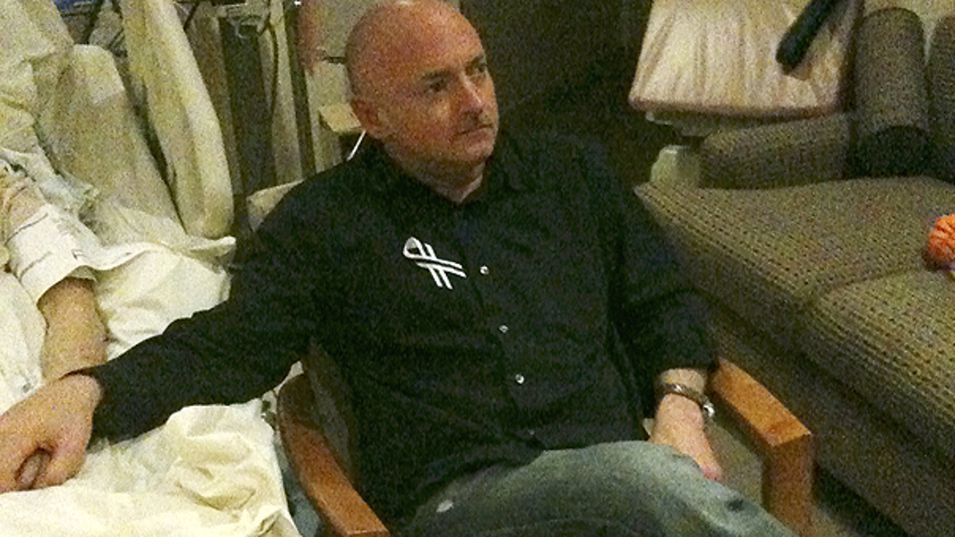 Jan. 25: A photo released by the office of U.S. Rep. Gabrielle Giffords shows Rep. Giffords husband Mark Kelly watching the State of The Union speech while holding his wife's hand in her hospital room in Houston.