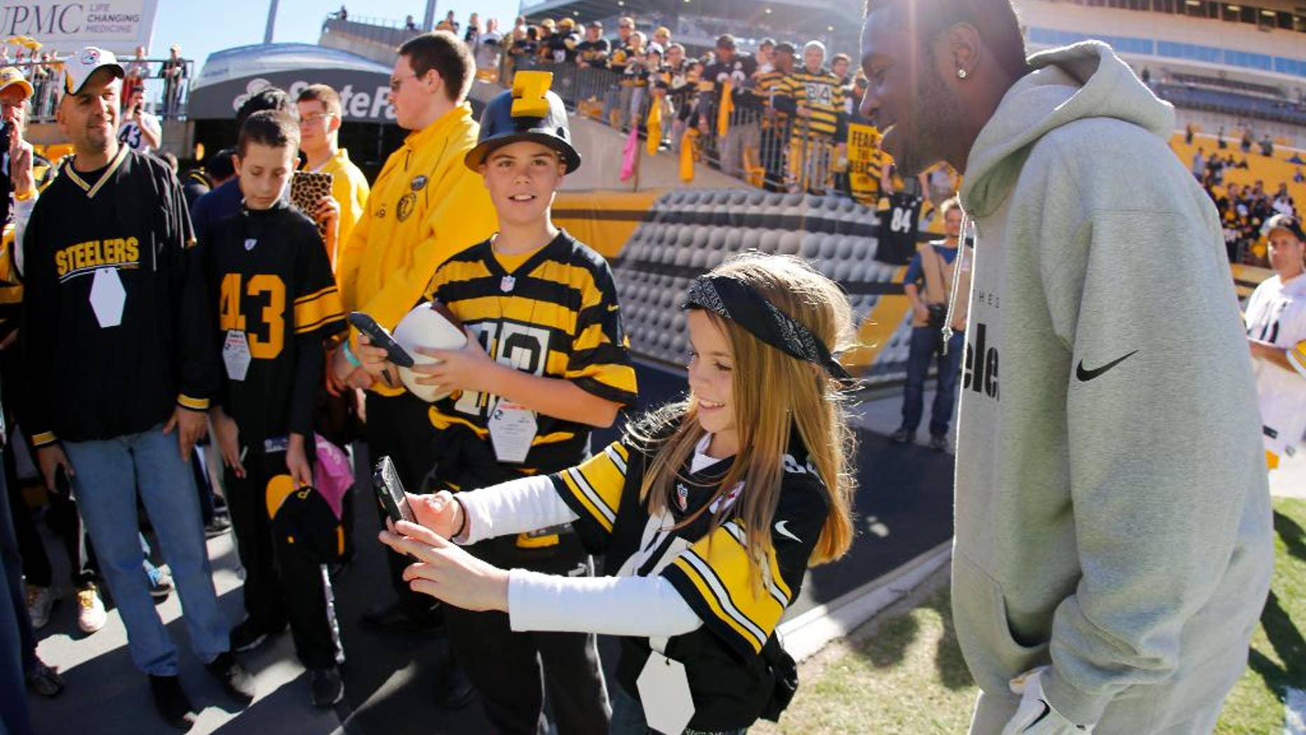 Pittsburgh Steelers wide receiver Antonio Brown, right, has his photo taken with fans during warmups before an NFL football game against the Indianapolis Colts, Sunday, Oct. 26, 2014, in Pittsburgh. (AP Photo/Gene Puskar)