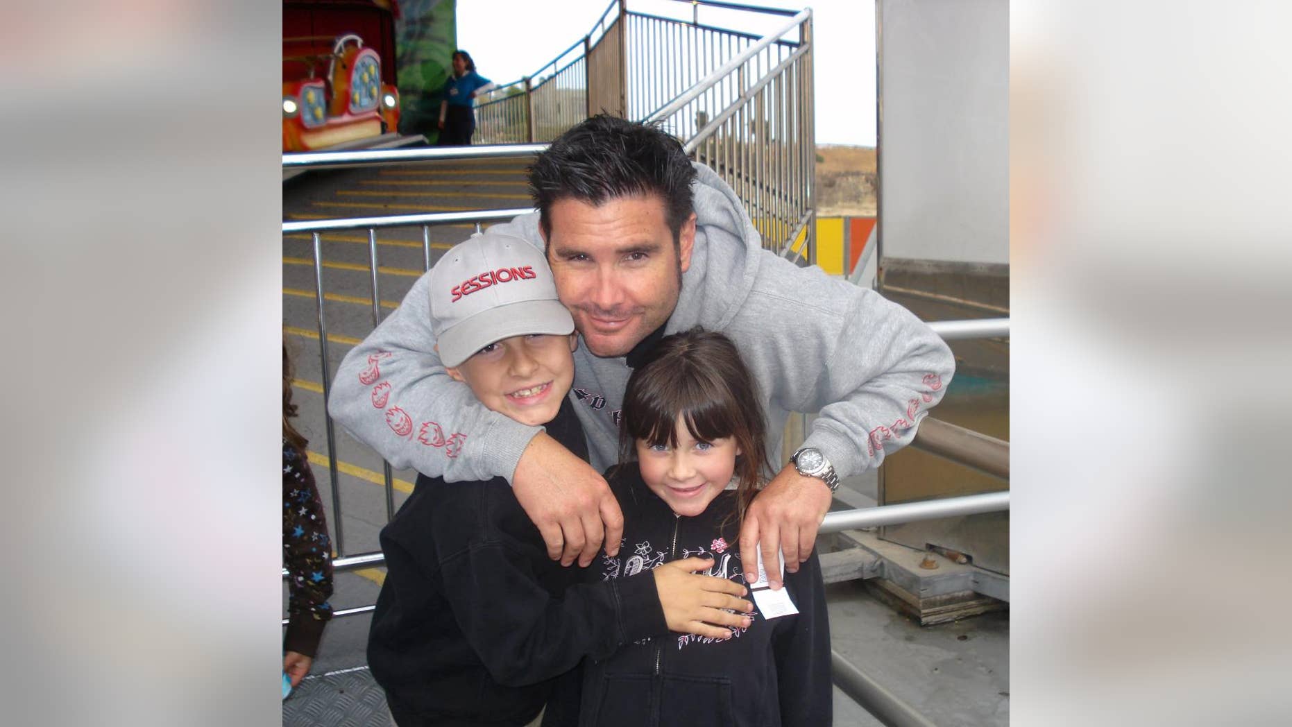 FILE - This undated file photo provided Tuesday April 5, 2011 by John Stow shows Bryan Stow holding his 12-year-old son and 8-year-old daughter. Stow who suffered a traumatic brain injury after being beaten by two Dodger fans put up his hands and fingers, fist bumped his mom and talked about his goals in a new interview three years after the attack outside Dodger Stadium. Stow, wearing a Giants tank top, spoke to ESPN on Tuesday, Oct. 21, 2014 from his parents’ home in the Northern California city of Capitola, where he watched Game 1 of the World Series between the Giants and Kansas City Royals. (AP Photo/John Stow, File)