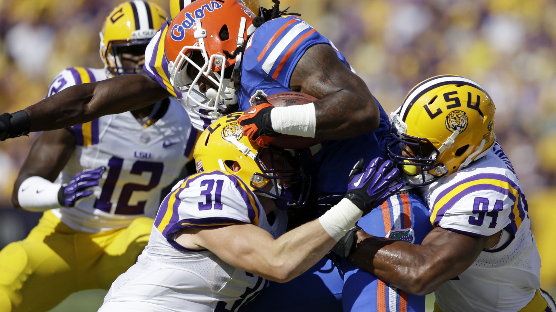 Florida running back Matt Jones is tackled by LSU linebacker D.J. Welter (31) and defensive end Danielle Hunter (94)in the first half of an NCAA college football game in Baton Rouge, La., Saturday, Oct. 12, 2013. (AP Photo/Gerald Herbert)