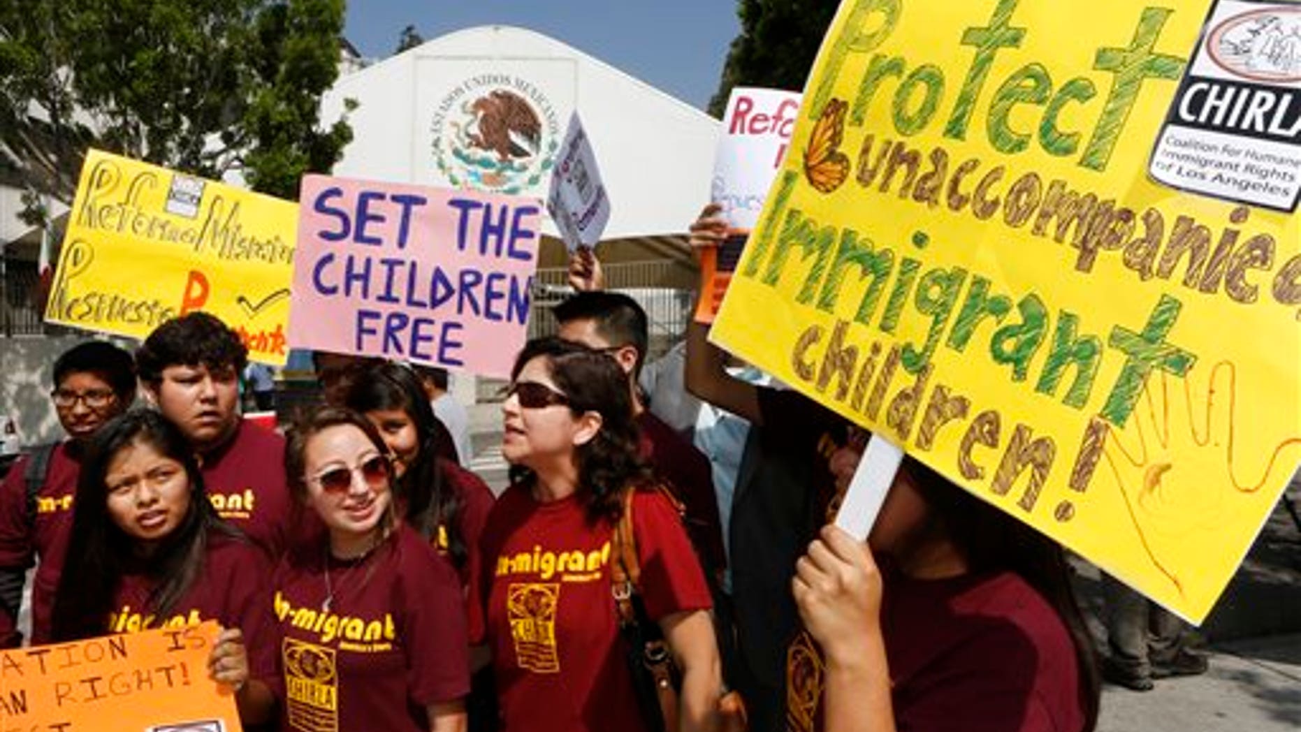 Immigration activists with Coalition for Humane Immigrant Rights of Los Angeles (CHIRLA) demand the Mexican government take more measures to protect and respect the rights of unaccompanied minors and families crossing Mexico's territory, during a protest outside the Mexican consulate in Los Angeles Thursday, July 3, 2014. Activists demand support of migrant children and families Thursday, two days after U.S. Homeland Security buses carrying the migrants were routed away from American flag-waving protesters in Murrieta, Calif., and transported to a facility in San Diego. (AP Photo/Damian Dovarganes)