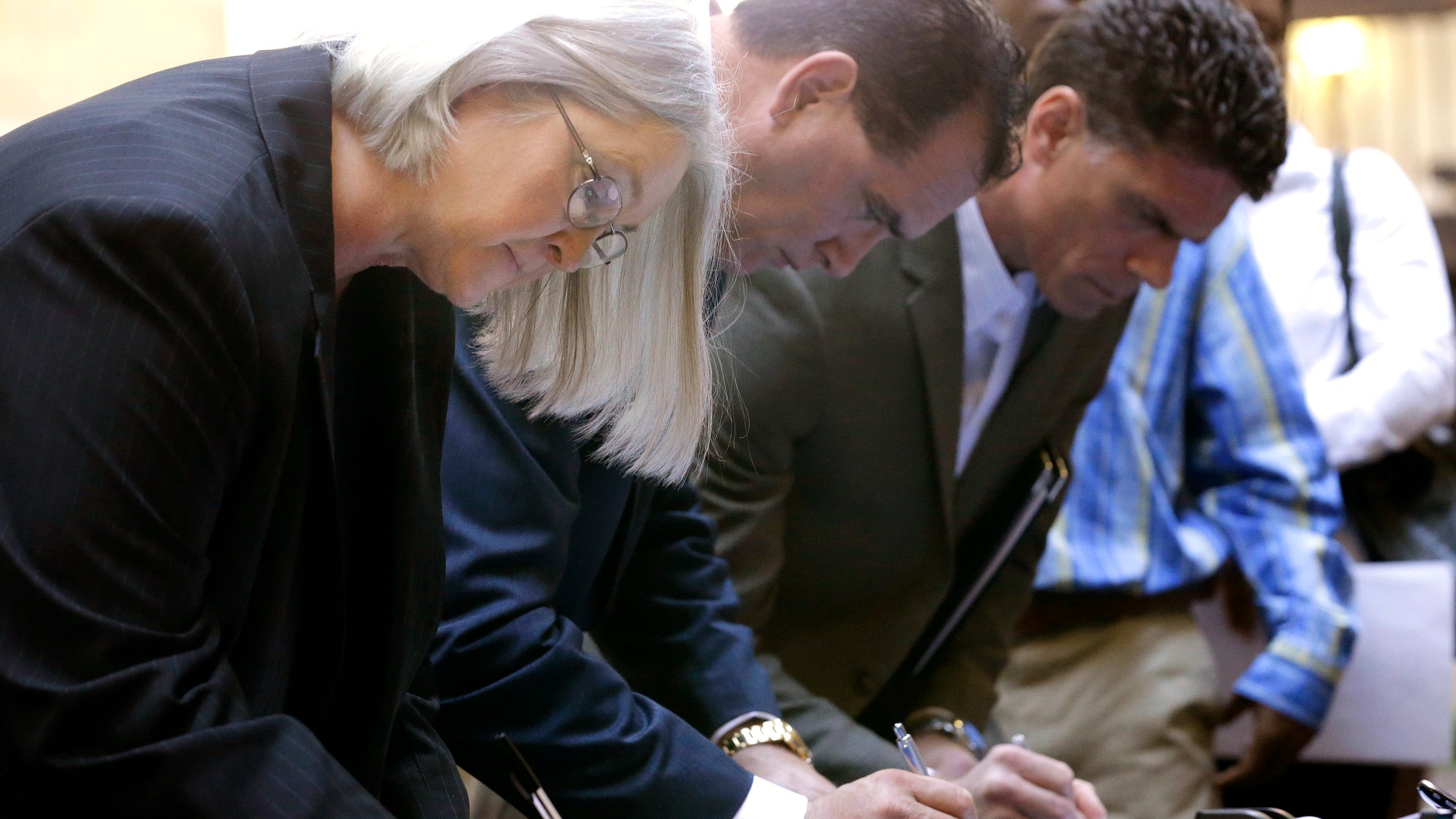 In this Wednesday, Jan. 22, 2014, photo, job seekers sign in before meeting prospective employers during a career fair at a hotel in Dallas. The government reports on state unemployment rates for December on Tuesday, Jan. 28, 2014. (AP Photo/LM Otero)