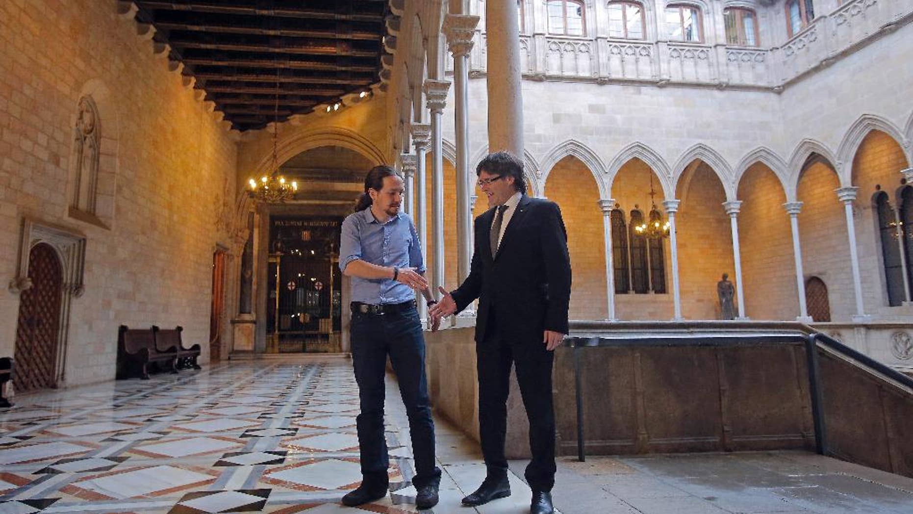 Catalan regional President Carles Puigdemont, right, shakes hands with Podemos Party leader Pablo Iglesias at the Generalitat Palace in Barcelona, Spain, Friday, April 8, 2016. The leader of Spain’s far left Podemos party has announced party members will vote next week on whether to support or oppose a deal to form a government and end nearly four months of political stalemate. Pablo Iglesias made the announcement Friday, a day after he met with negotiators for the Socialists and the centrist Ciudadanos party. They have a deal to form a government but lack parliamentary support and could get it from Podemos. (AP Photo/Manu Fernandez)