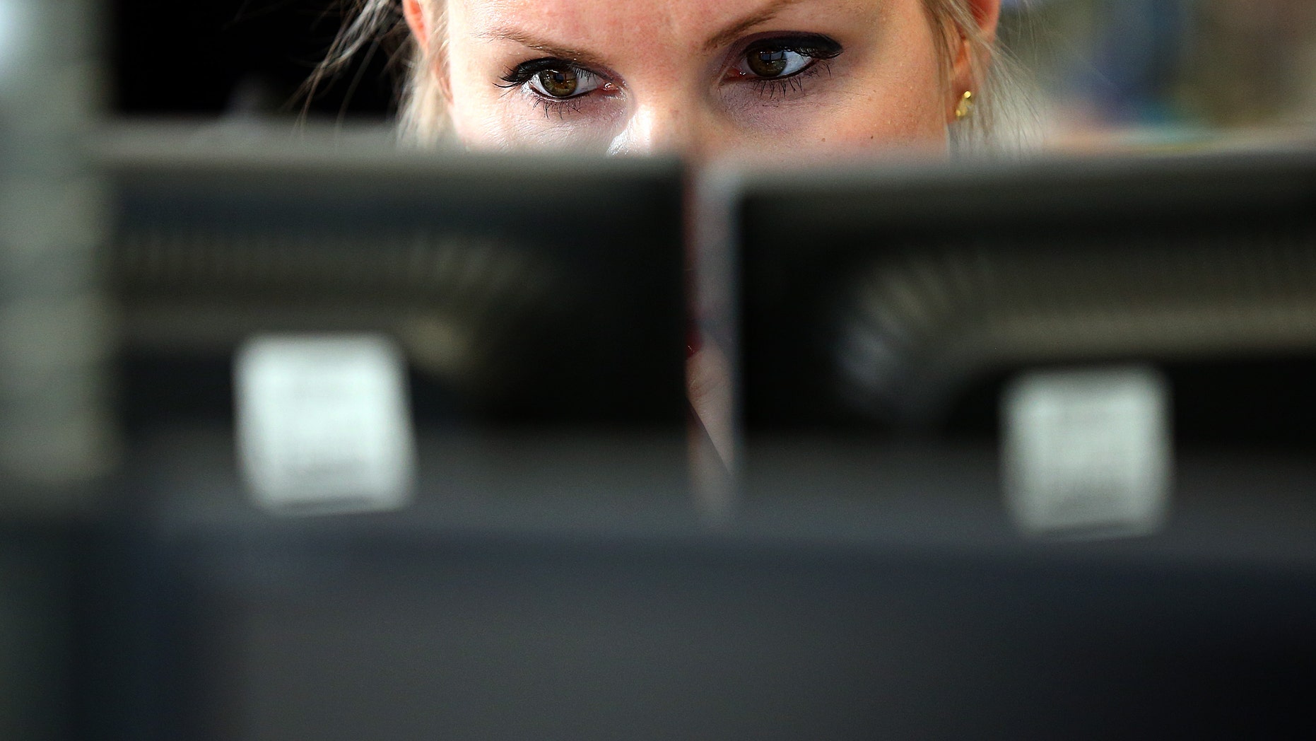 LONDON, ENGLAND - OCTOBER 20: An employee views trading screens at the offices of Panmure Gordon and Co on October 20, 2014 in London, England. Markets stabilised over the weekend following global turbulence amid fears over the Ebola virus and global economic concerns. (Photo by Carl Court/Getty Images)