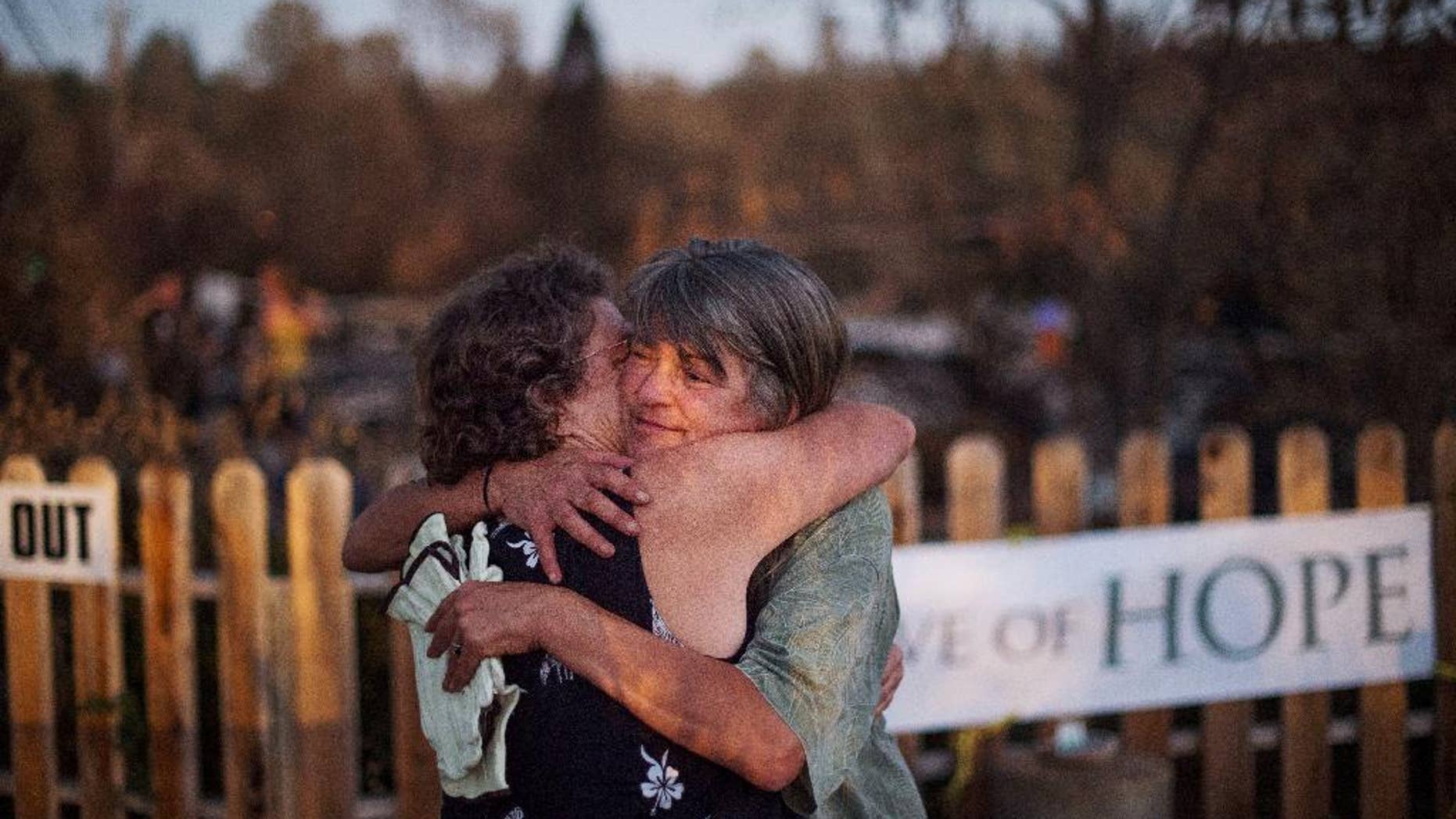 Sharon Dawson, right, who lost her home in a wildfire, embraces a friend while visiting her Middletown, Calif., property on Monday, Sept. 21, 2015. Gov. Jerry Brown requested a presidential disaster declaration on Monday, noting that more than 1,000 homes had been confirmed destroyed, with the number likely to go higher as assessment continues. (AP Photo/Noah Berger)