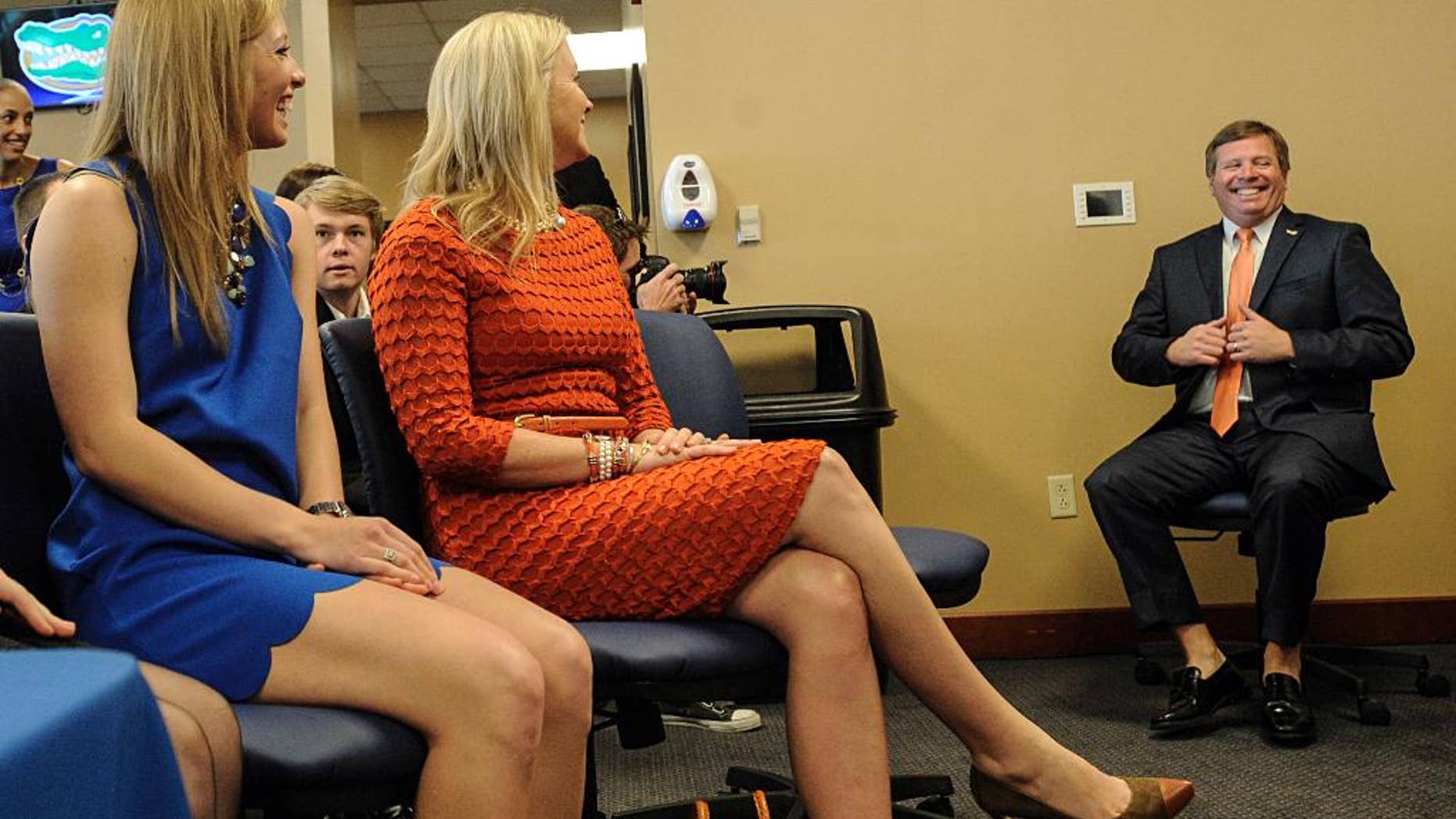 Jim McElwain, right, Florida's new head football coach, waites to be introduced as his daughter JoHanna, left, and wife Karen, center, look on during an NCAA college football news conference, Saturday, Dec. 6, 2014, in Gainesville, Fla. (AP Photo/Phil Sandlin)