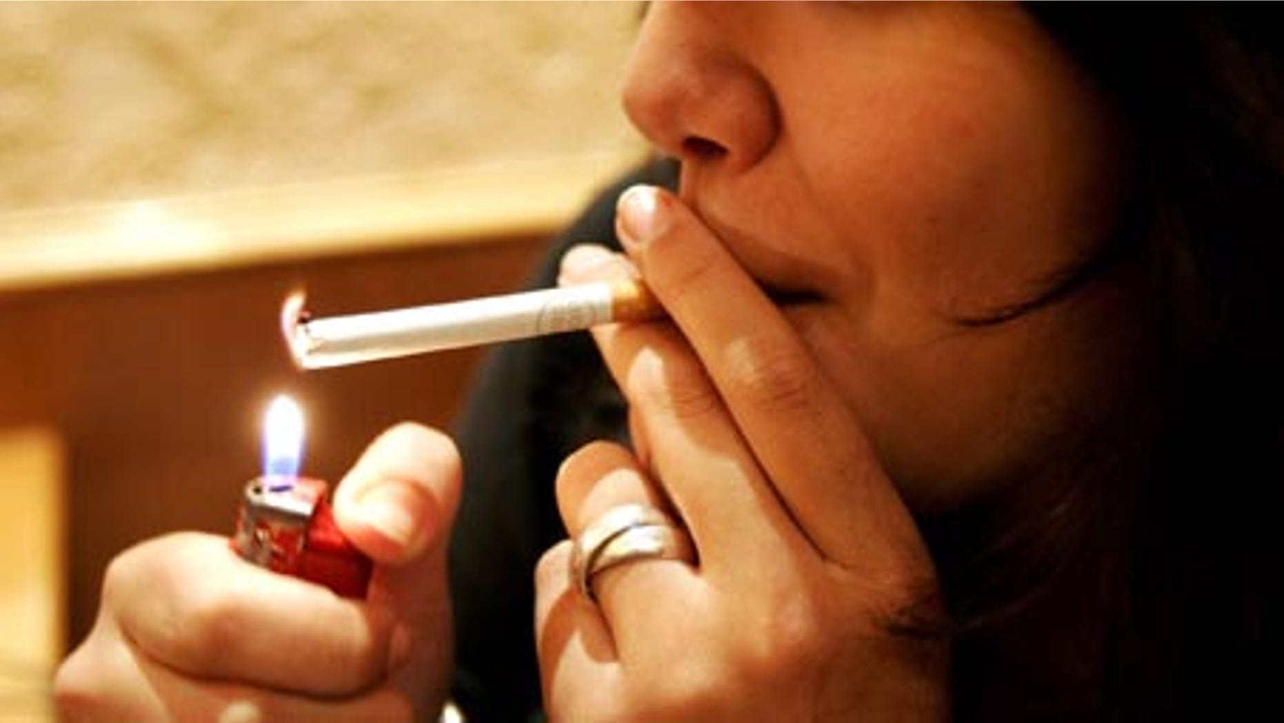 A student lights a cigarette in a cafe in Paris, Tuesday Oct. 3, 2006 in Paris. A parliamentary panel in cigarette-friendly France called Tuesday for the government to ban smoking in public places like cafes and restaurants in less than a year and floated the prospect of special "smoking rooms." (AP Photo/Francois Mori)