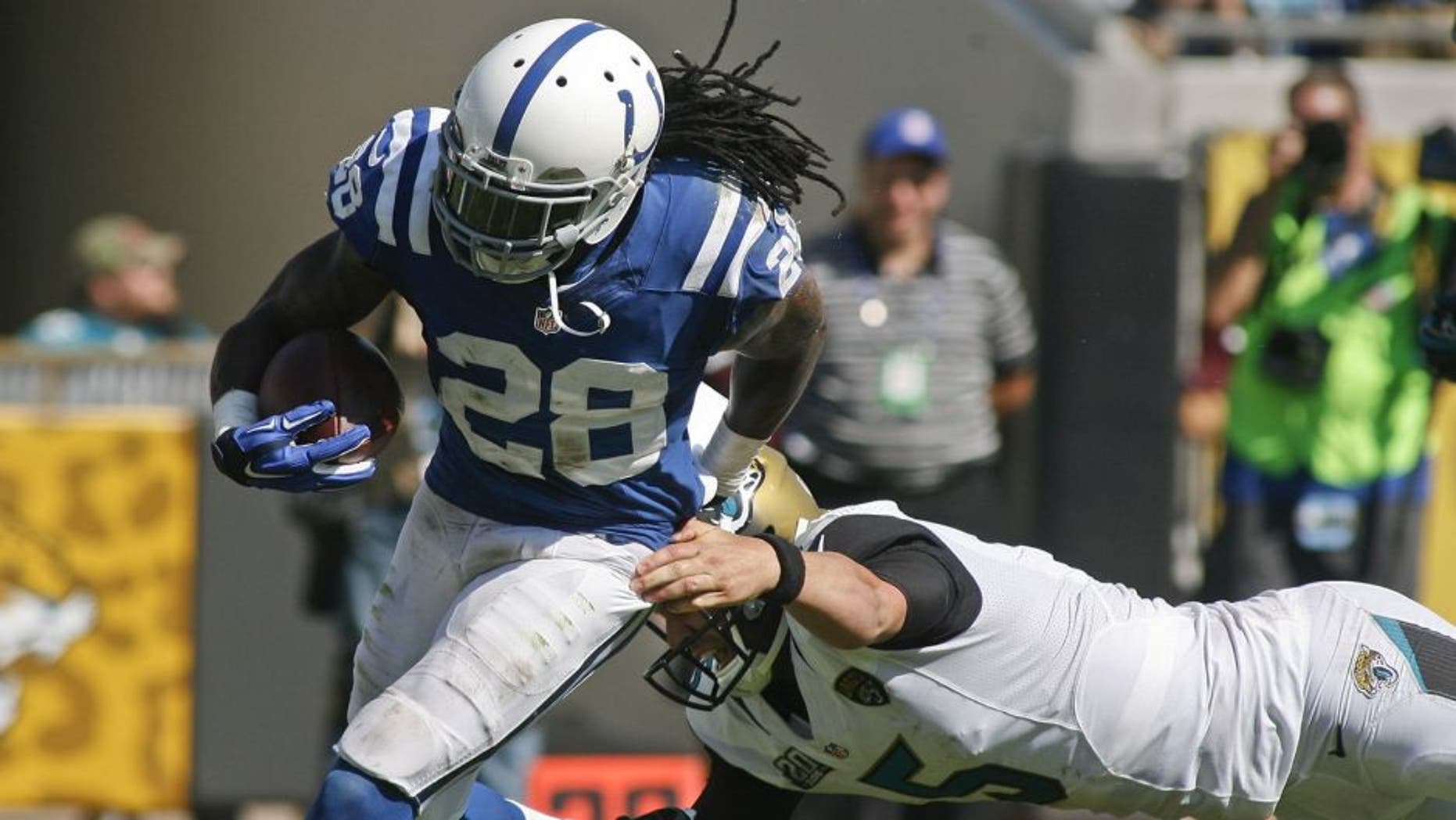 Sep 21, 2014; Jacksonville, FL, USA; Indianapolis Colts cornerback Greg Toler (28) escapes the grasp of Jacksonville Jaguars quarterback Blake Bortles (5) to return an interception for a touchdown in the fourth quarter of their game at EverBank Field. The Colts won 44-17. Mandatory Credit: Phil Sears-USA TODAY Sports