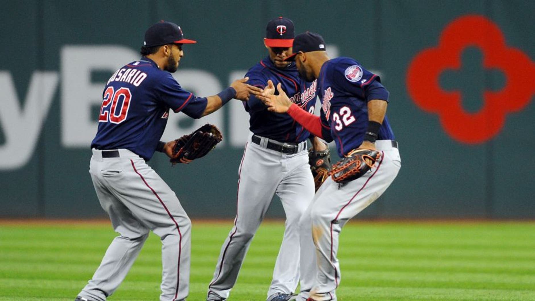 Oct 1, 2015; Cleveland, OH, USA; Minnesota Twins left fielder Eddie Rosario (20), center fielder Byron Buxton (25) and center fielder Aaron Hicks (32) celebrate the Twins 4-2 win over the Cleveland Indians at Progressive Field. Mandatory Credit: Ken Blaze-USA TODAY Sports