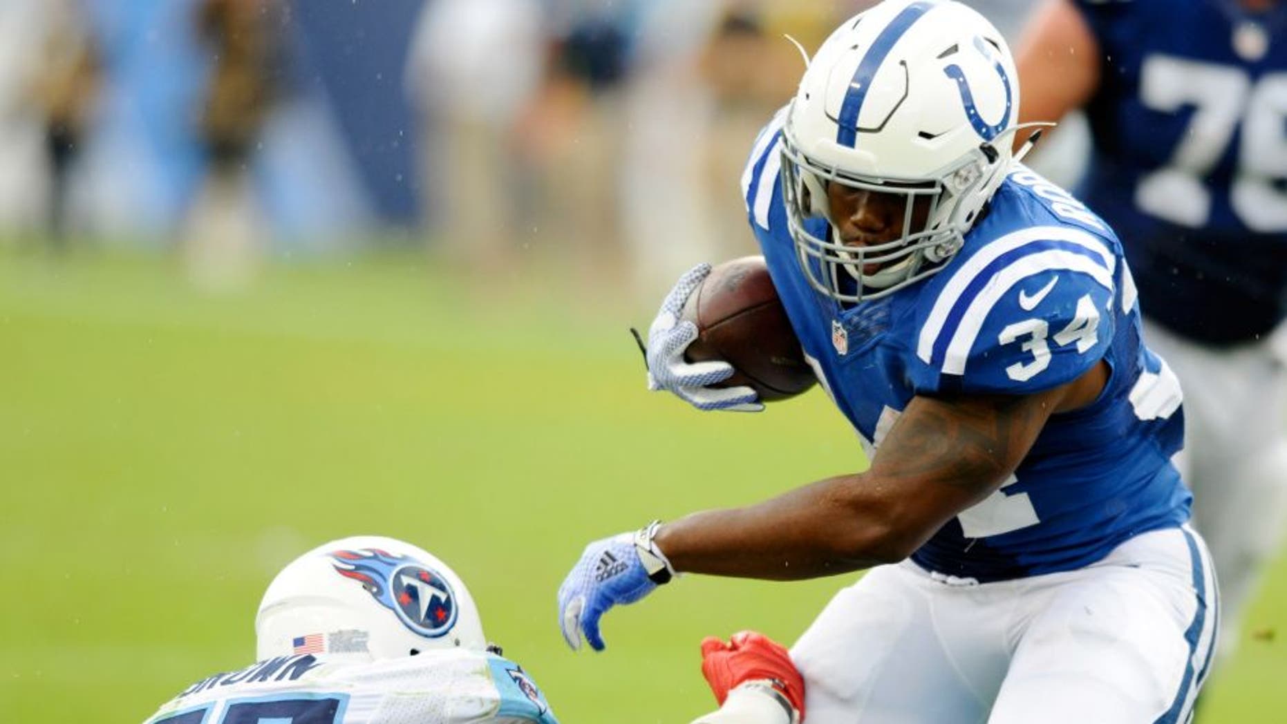 Sep 27, 2015; Nashville, TN, USA; Indianapolis Colts running back Josh Robinson (34) fights off a tackle during the second half against the Tennessee Titans at Nissan Stadium. The Colts won 35-33. Mandatory Credit: Christopher Hanewinckel-USA TODAY Sports