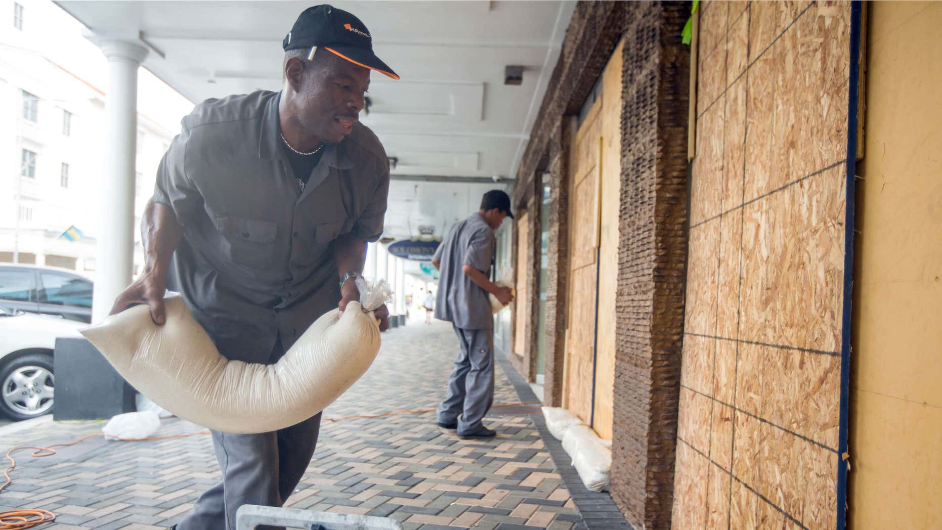 Oct. 1, 2015: Perry Williams, 47, left, and Alaric Nixon, 28, place sandbags on the storefront of Diamond's International store, in preparation for the arrival of hurricane Joaquin in Nassau, Bahamas.