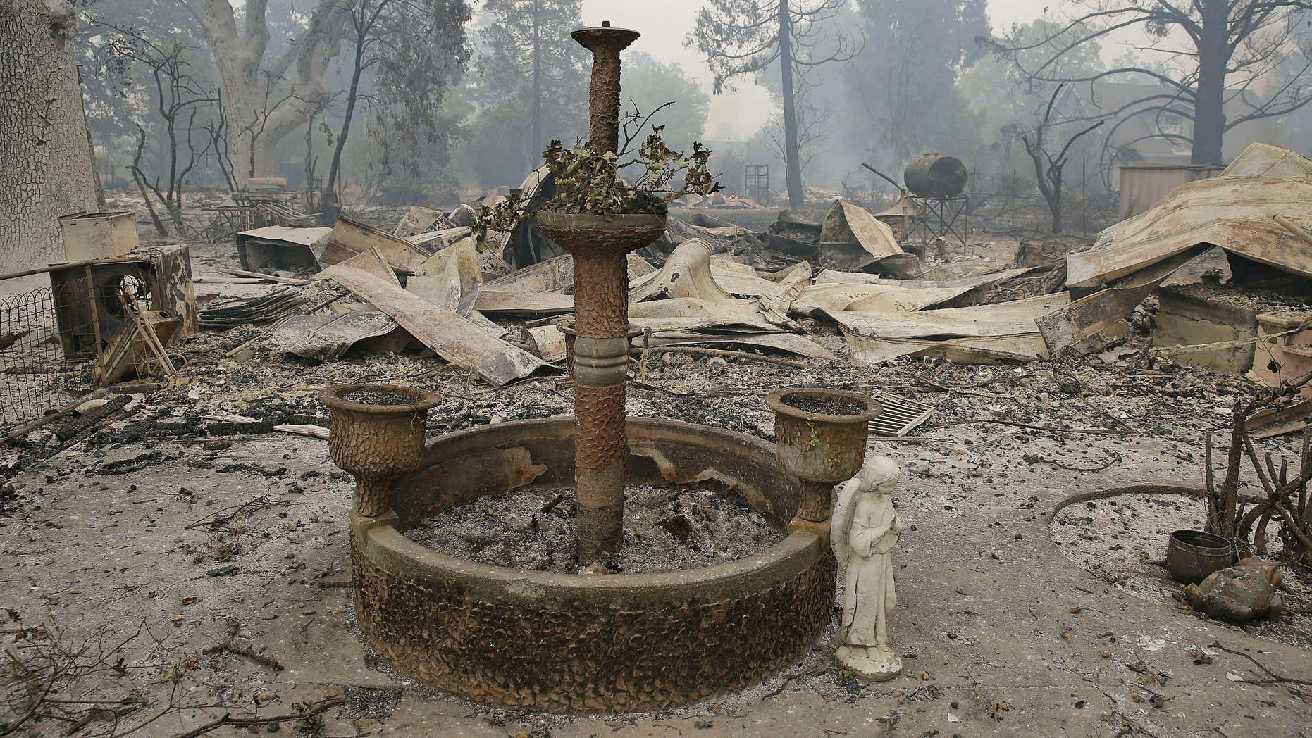 Sept. 13, 2015: A fountain and statue of an angel stand outside a home destroyed by fire in Middletown , Calif.