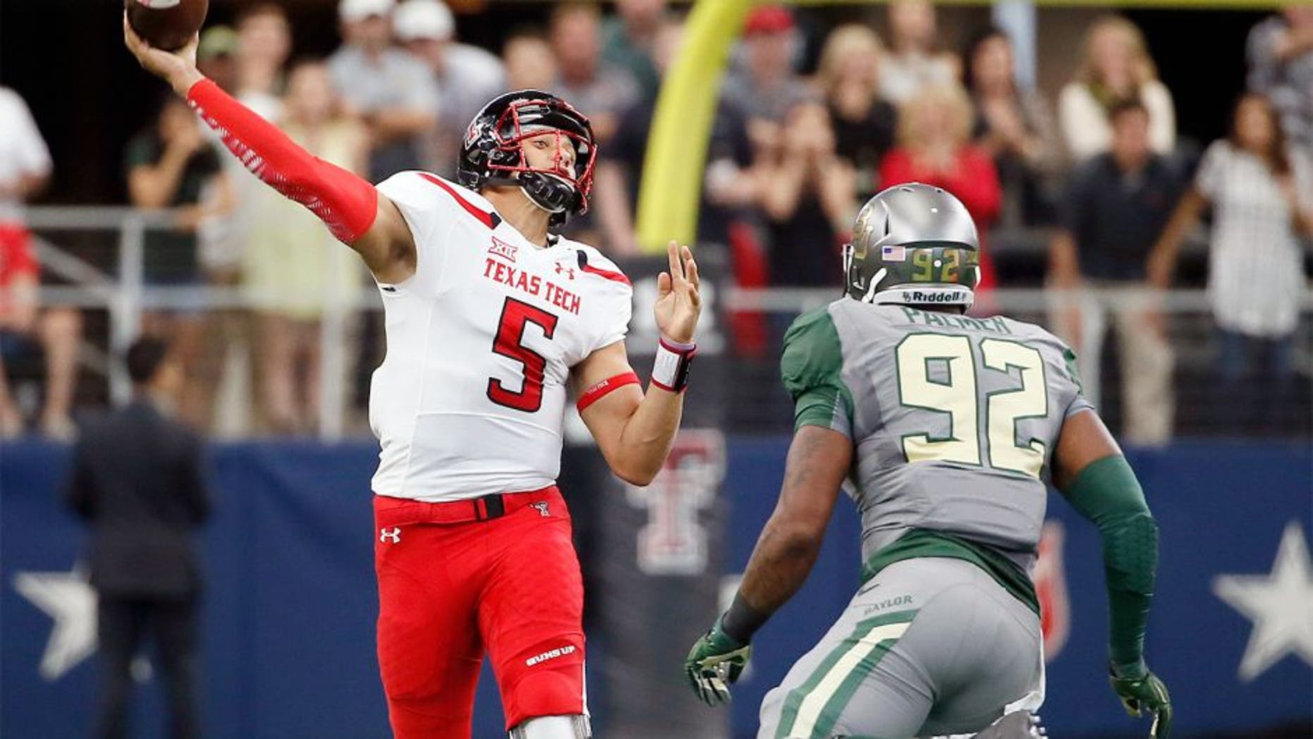 Texas Tech quarterback Patrick Mahomes (5) throws a long touchdown pass to wide receiver Zach Austin under pressure from Baylor defensive end Jamal Palmer (92) in the first half of an NCAA college football game Saturday, Oct. 3, 2015, in Arlington, Texas. (AP Photo/Tony Gutierrez)
